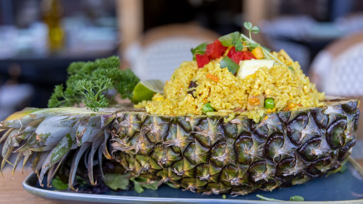 This recipe stays true to its Thai origins with bacon, raisins, peas, corn  served in a pineapple