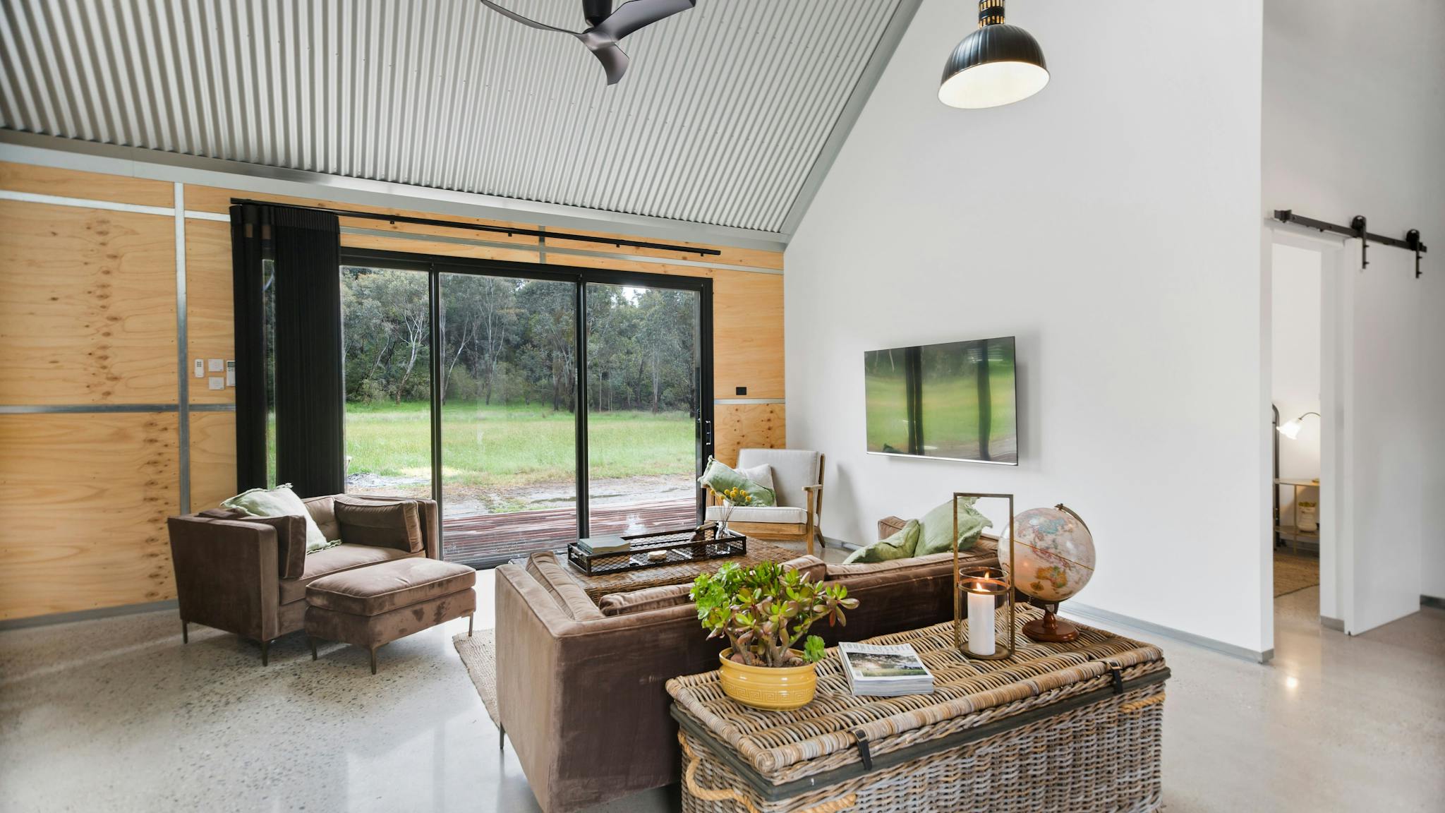 BIG Shed Lounge area with large sliding door , cathedral ceiling and fan