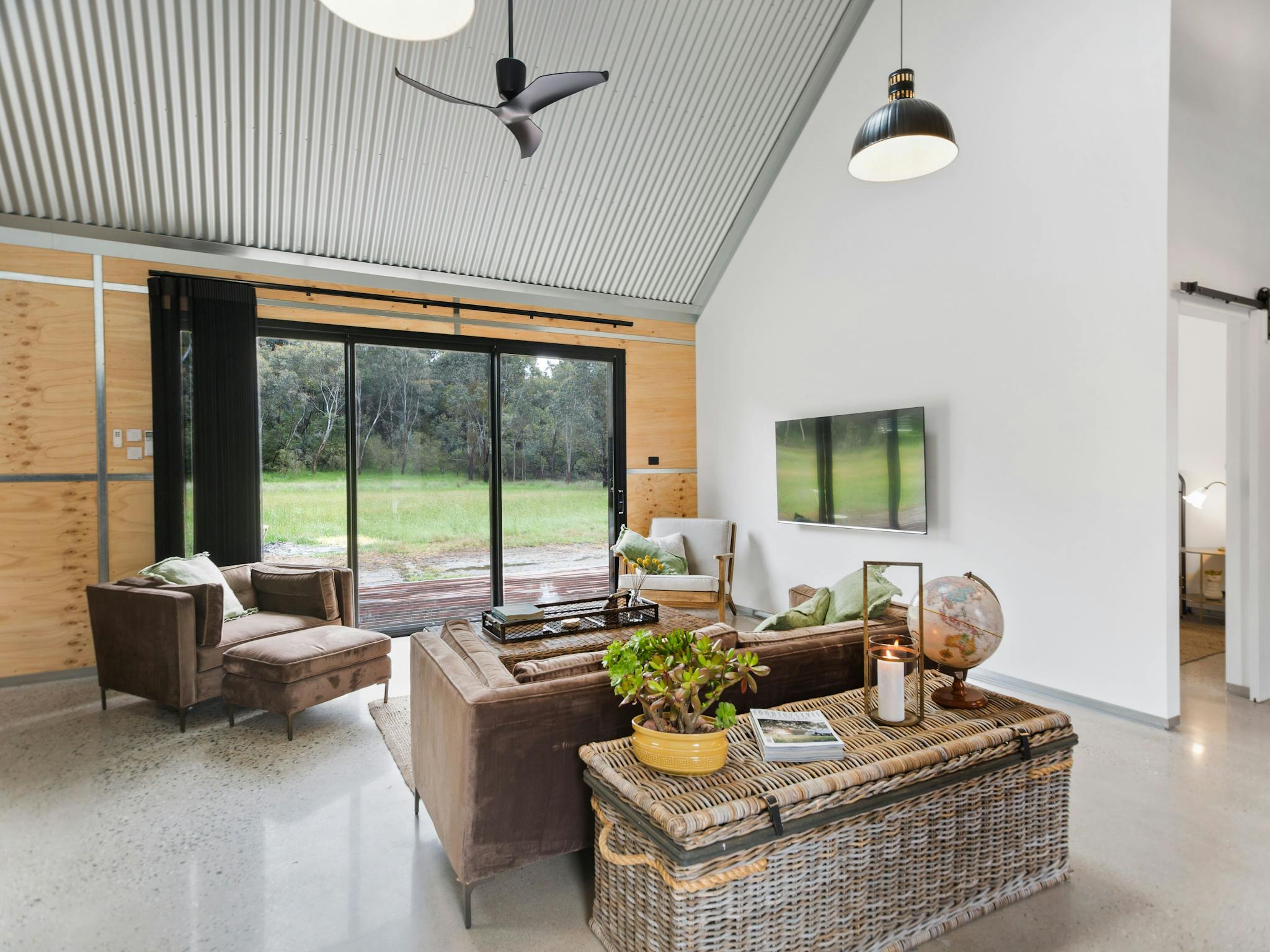 BIG Shed Lounge area with large sliding door , cathedral ceiling and fan