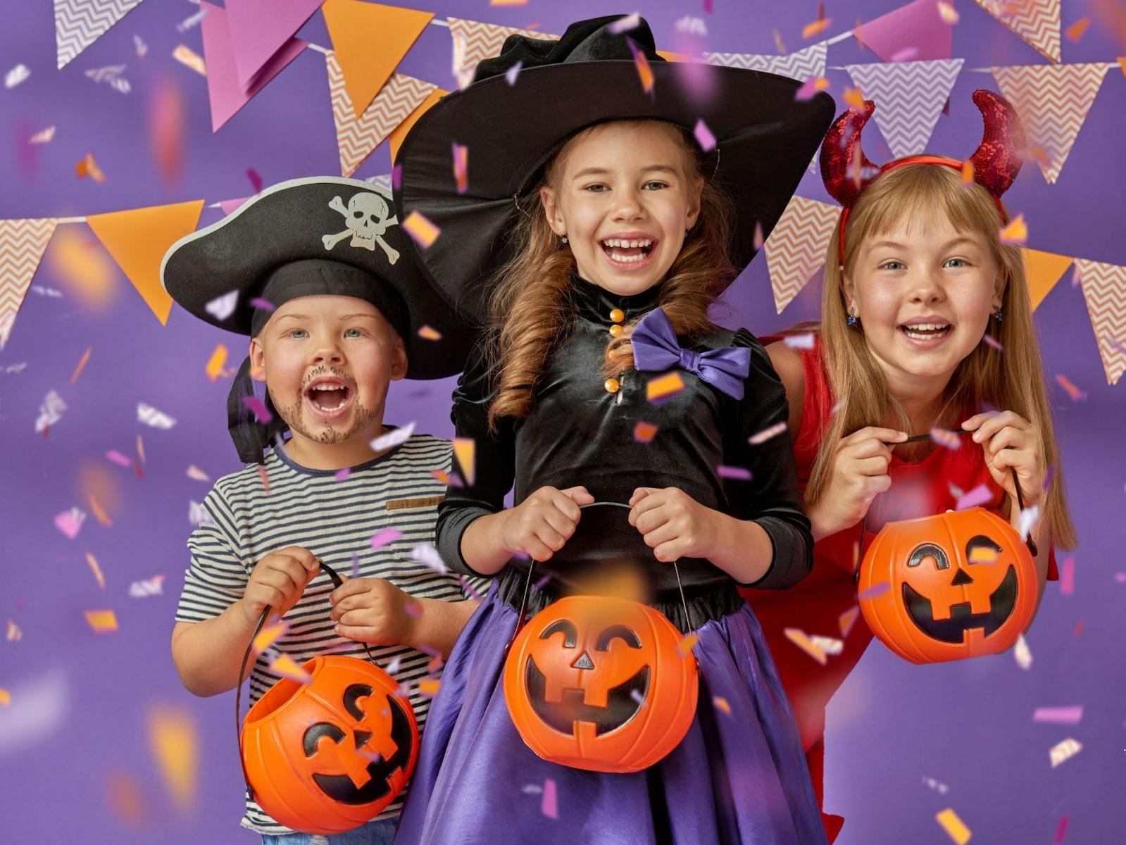 Three children dressed up in Halloween costumes