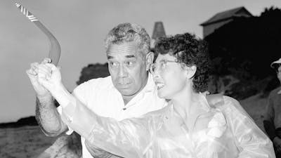 A man teaches women how to throw a boomerang in 1957.