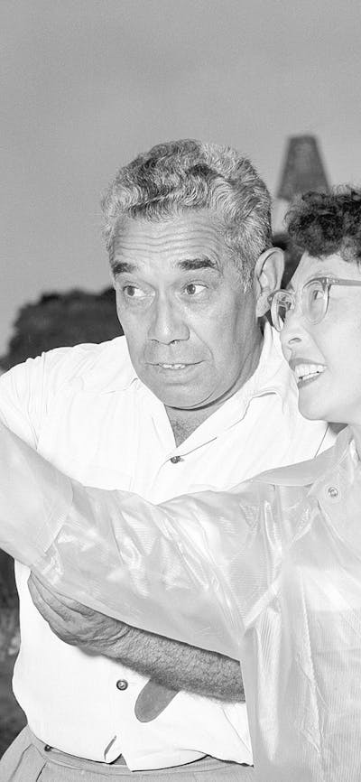 A man teaches women how to throw a boomerang in 1957.