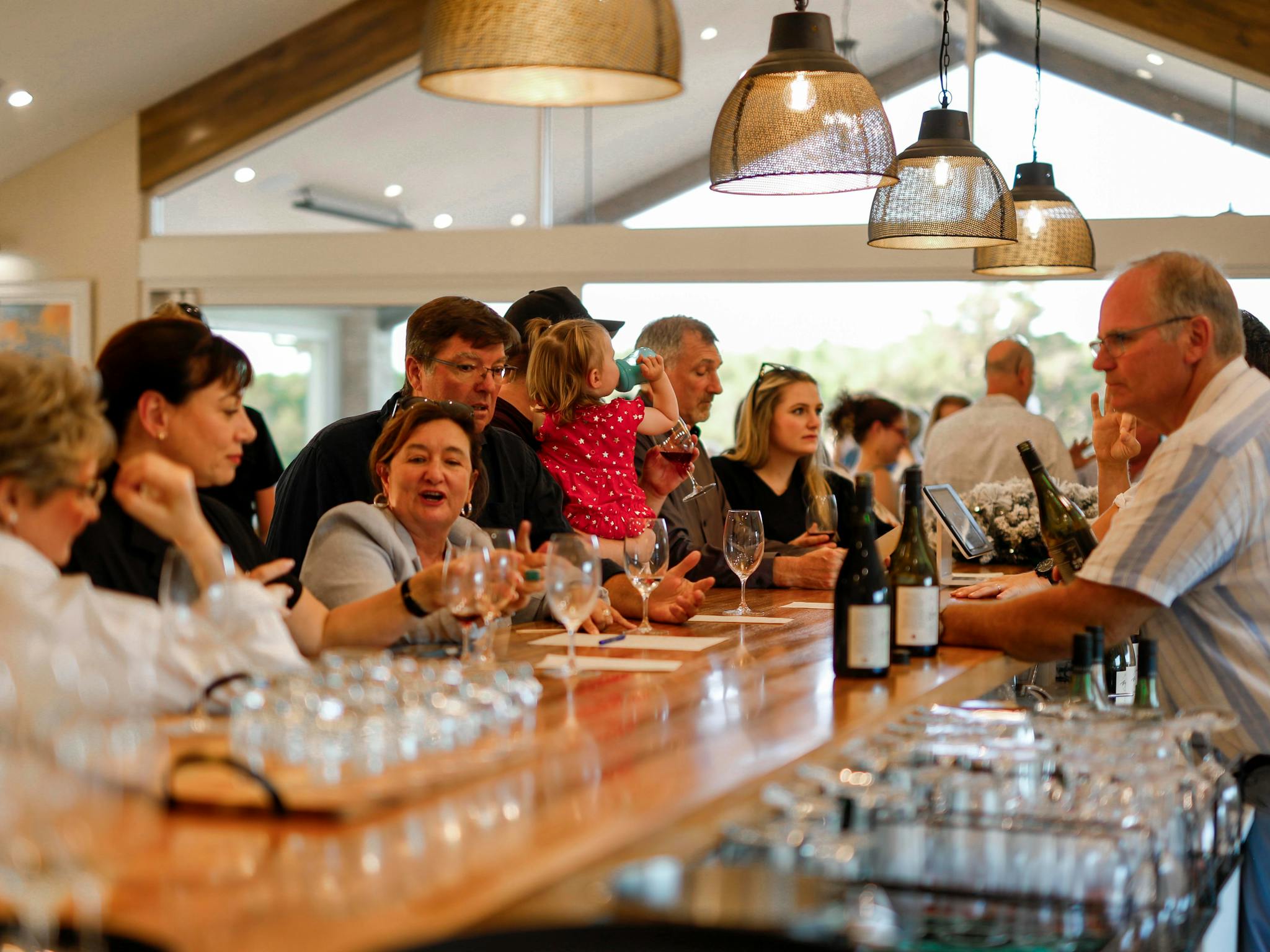 People gathered around a bar for a wine tasting.
