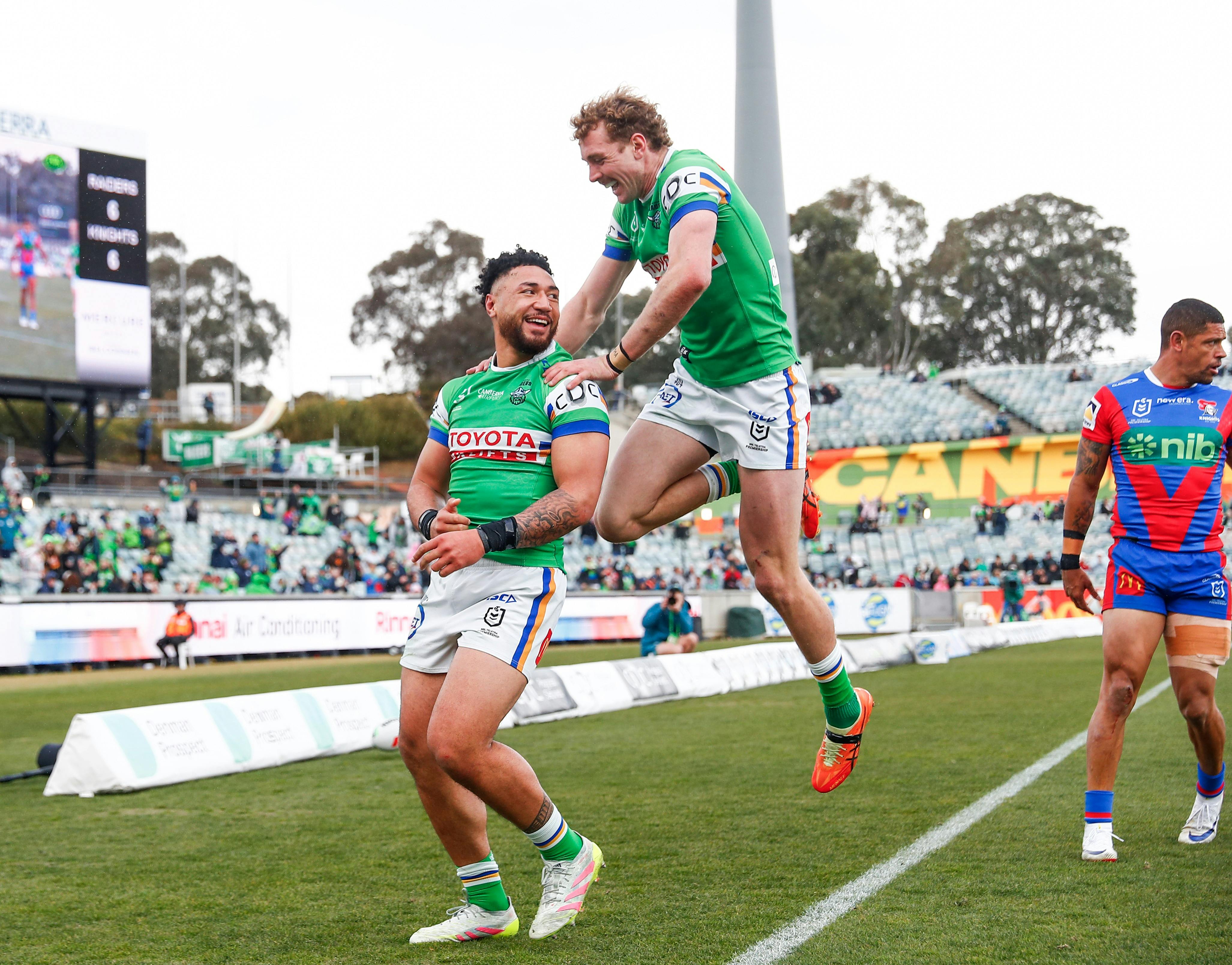 Canberra Raiders players Simi Sasagi and Jed Stuart celebrating a try.