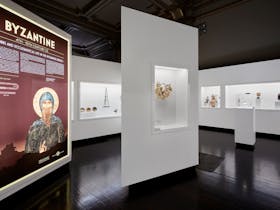 An exhibition of Greek antiquities including a gold wreath and Byzantine sign in the foreground