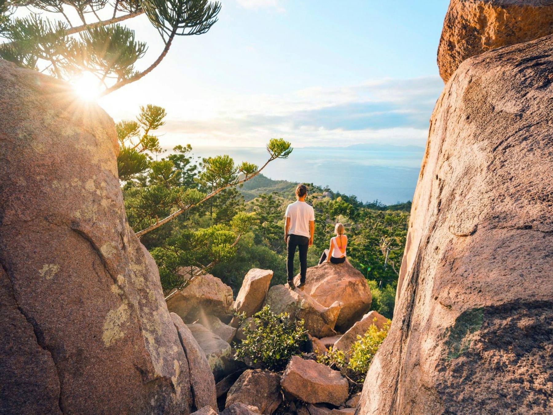 Two people sitting on a rock on a cliff face