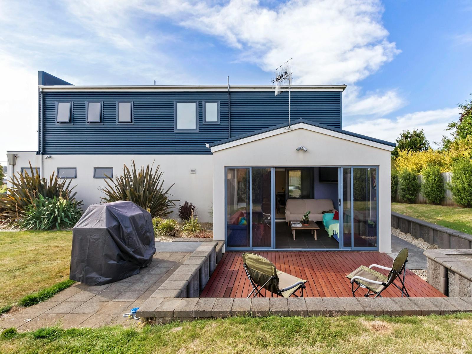 Large back yard with sunroom, outside deck and BBQ facilities