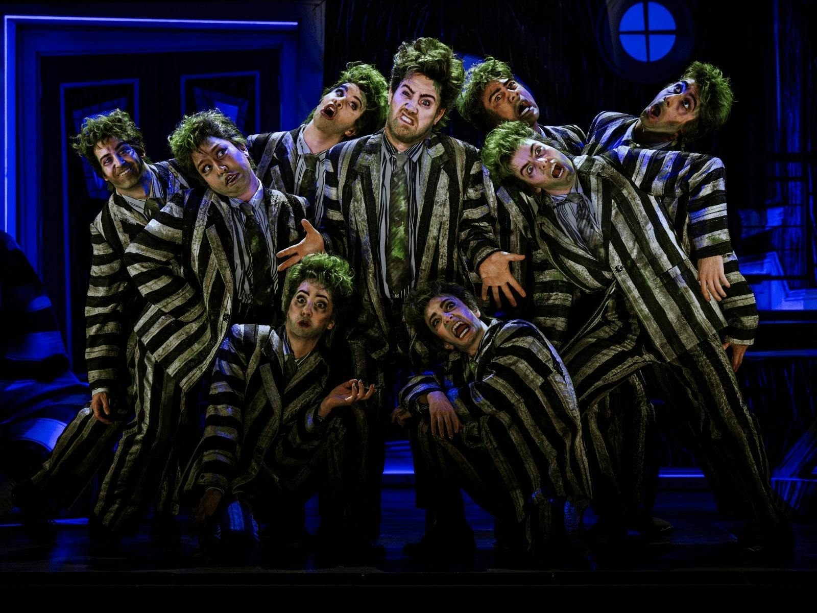 Beetlejuice and a group of demon clones stand together plotting their next move.