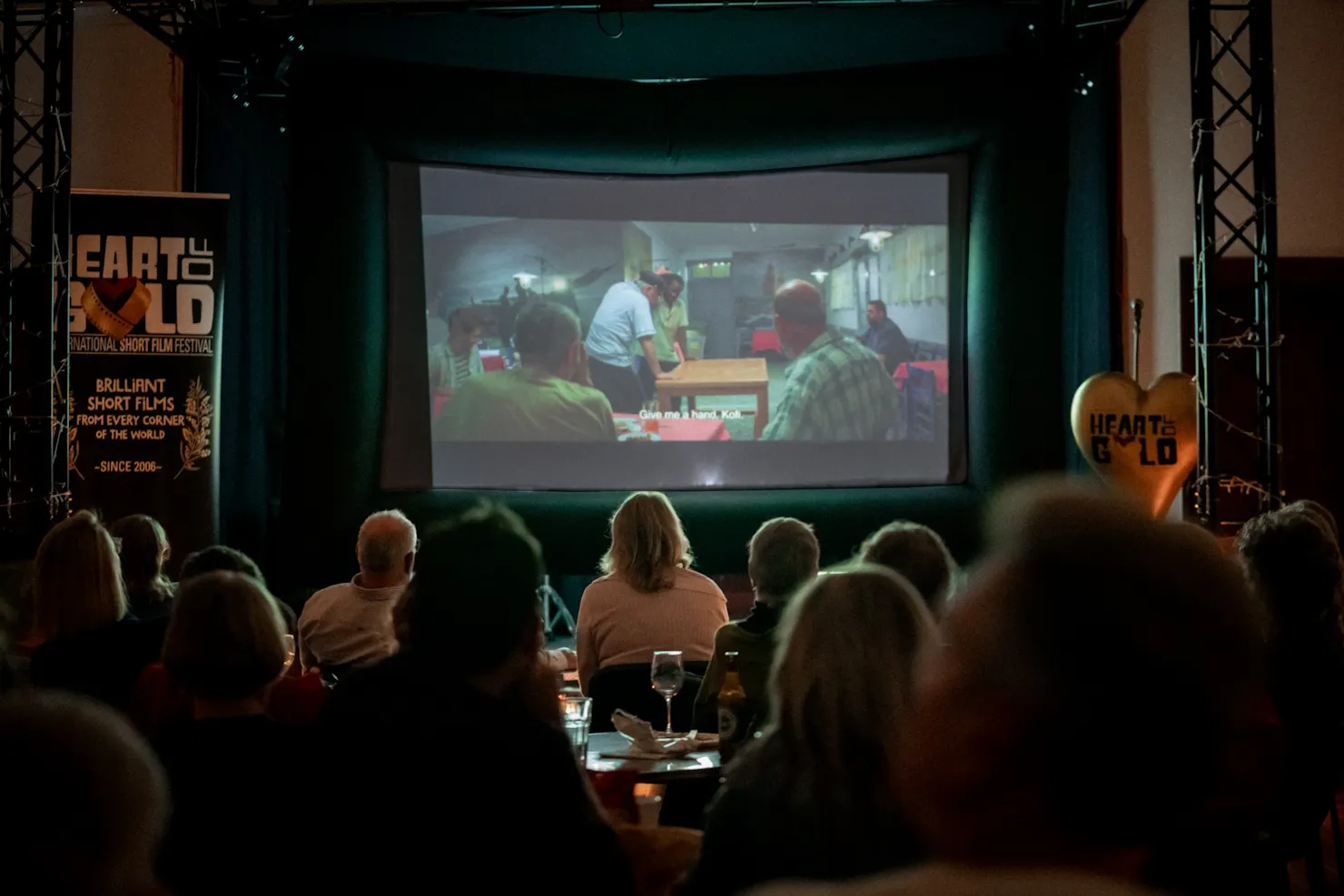 Darkened cinema with film showing and siloettes of audience