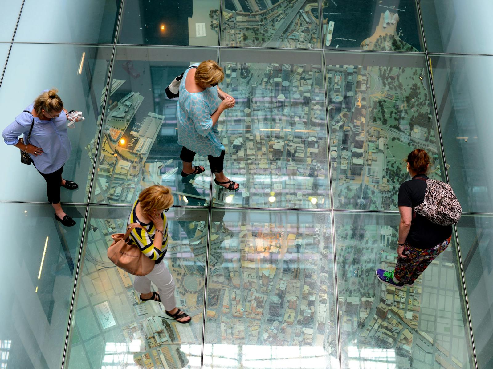 Sydney walking tour participants examine a miniature model of Sydney.