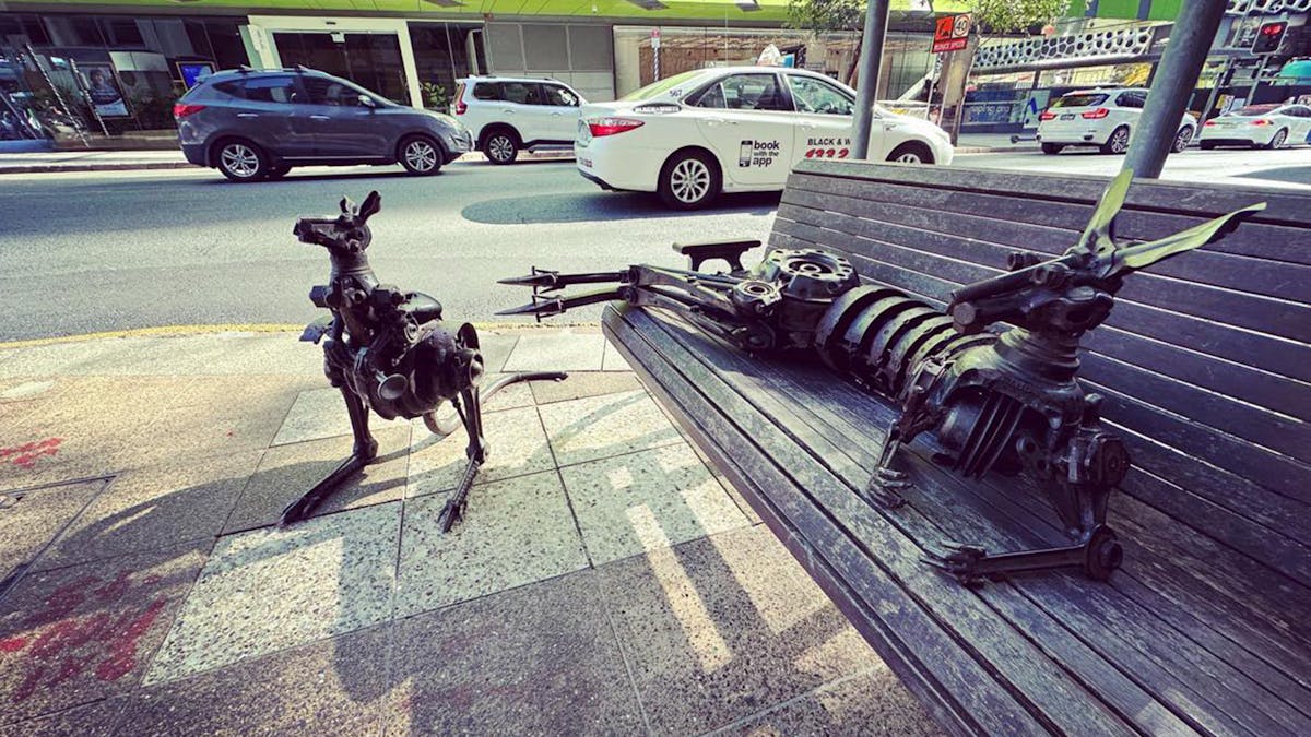 Kangaroo statues laying on bench