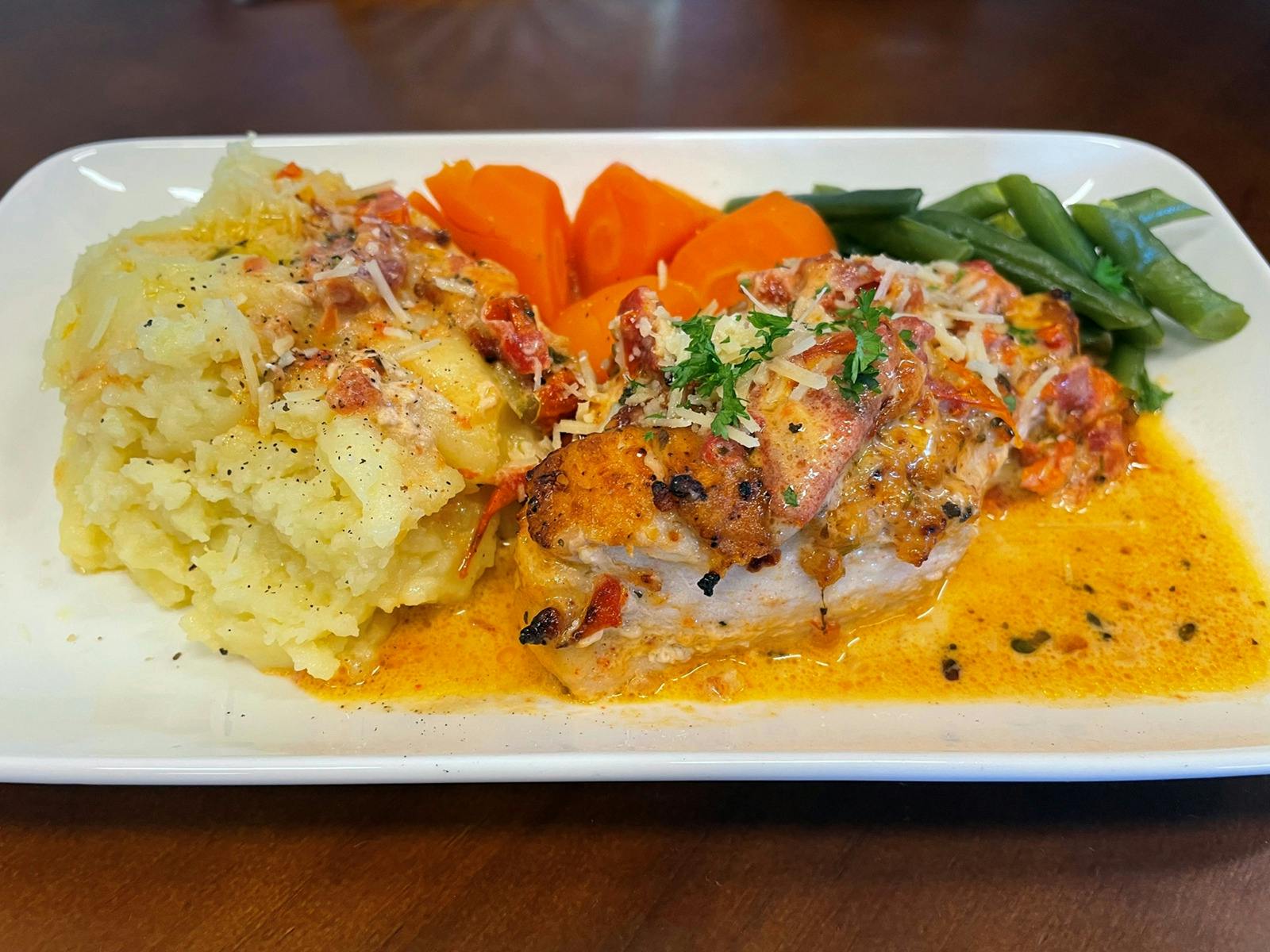 Tuscan Chicken with mashed potatoes and seasonal vegetables