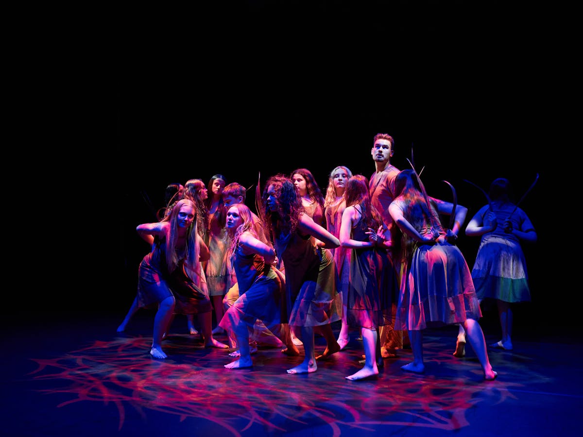 Photograph of dancers posing in purple light