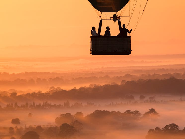 Balloon flight passengers watching the sunrise