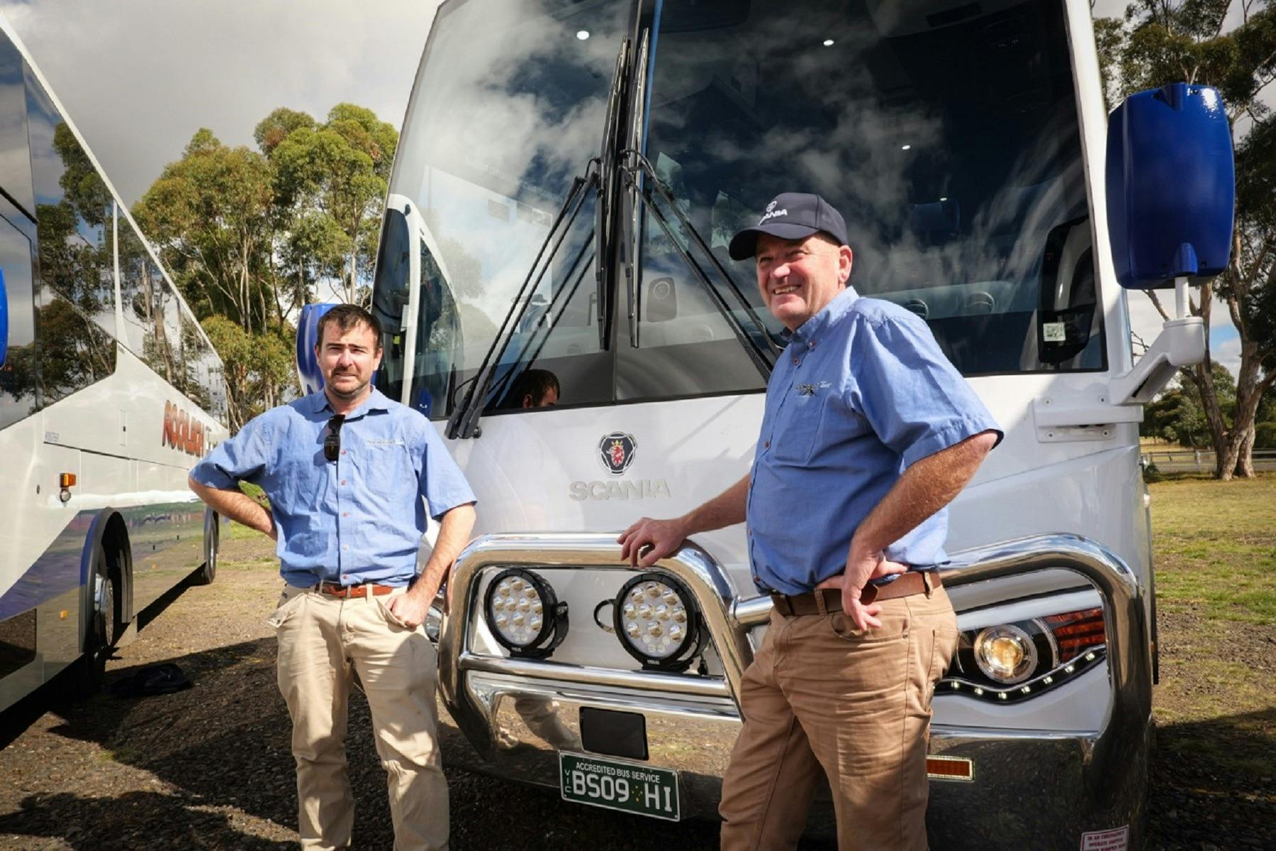 dad and son standing in front of bus