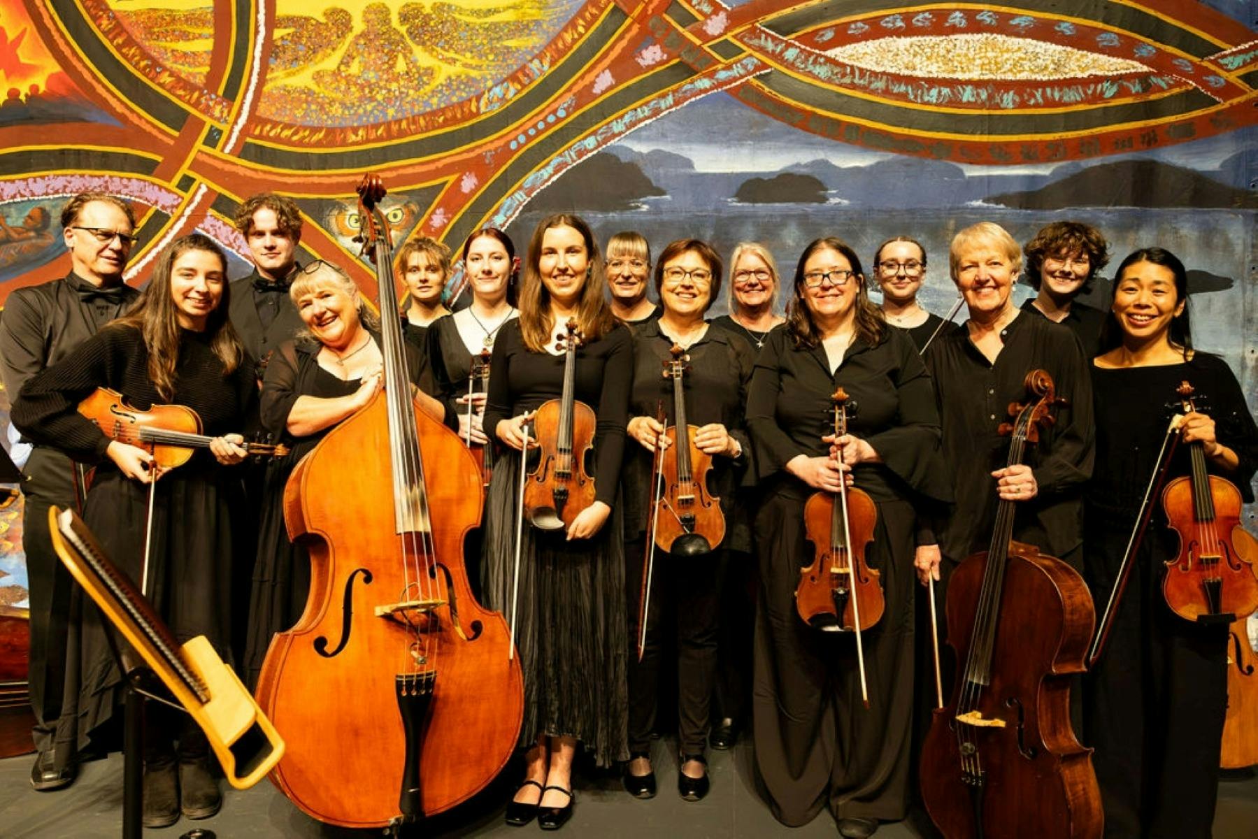 Men and women of the orchestra holding their instruments