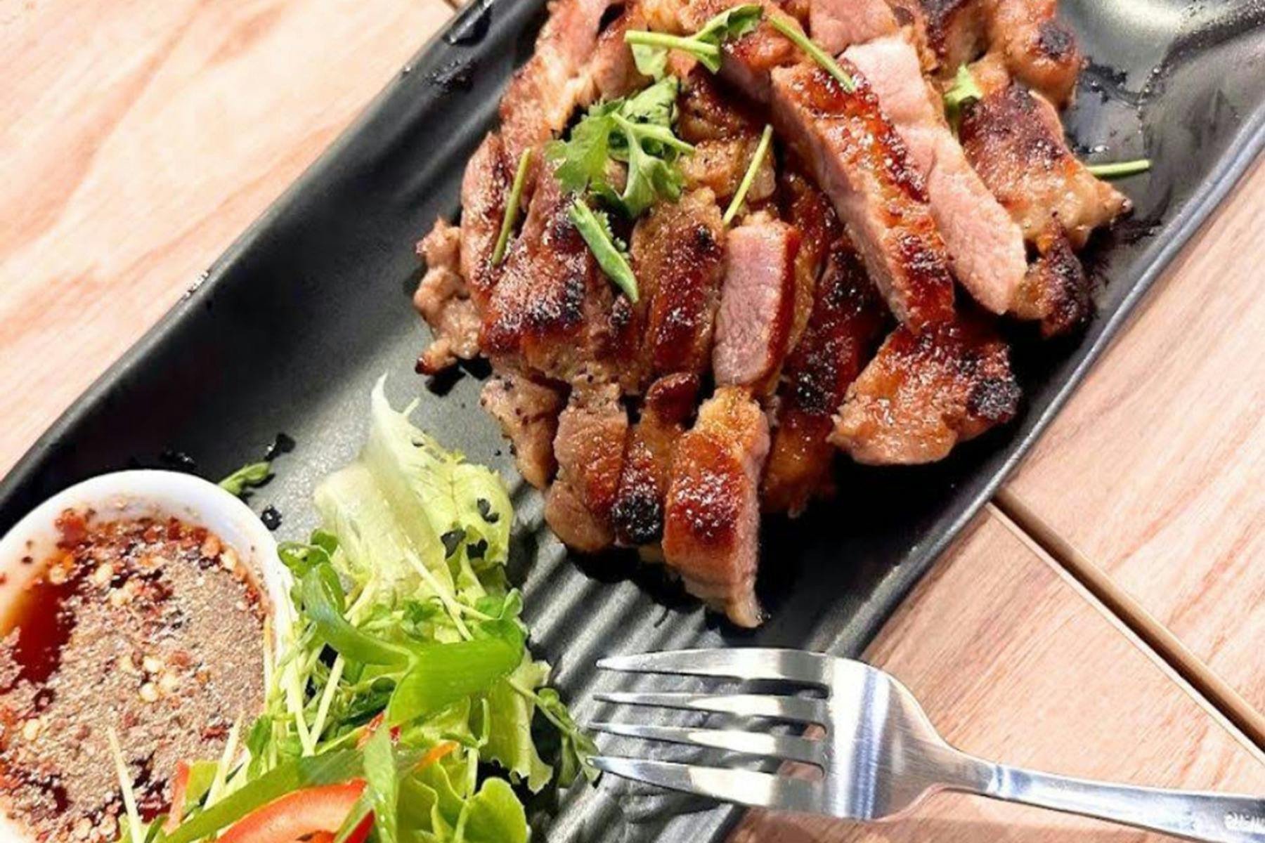 Barbequed pork neck with salad and sauce.
