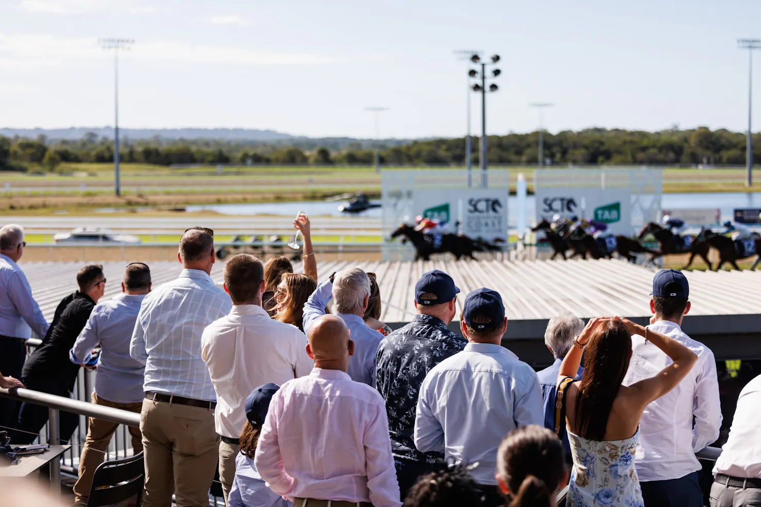 People watching and cheering on the thoroughbred horses crossing the finishing post