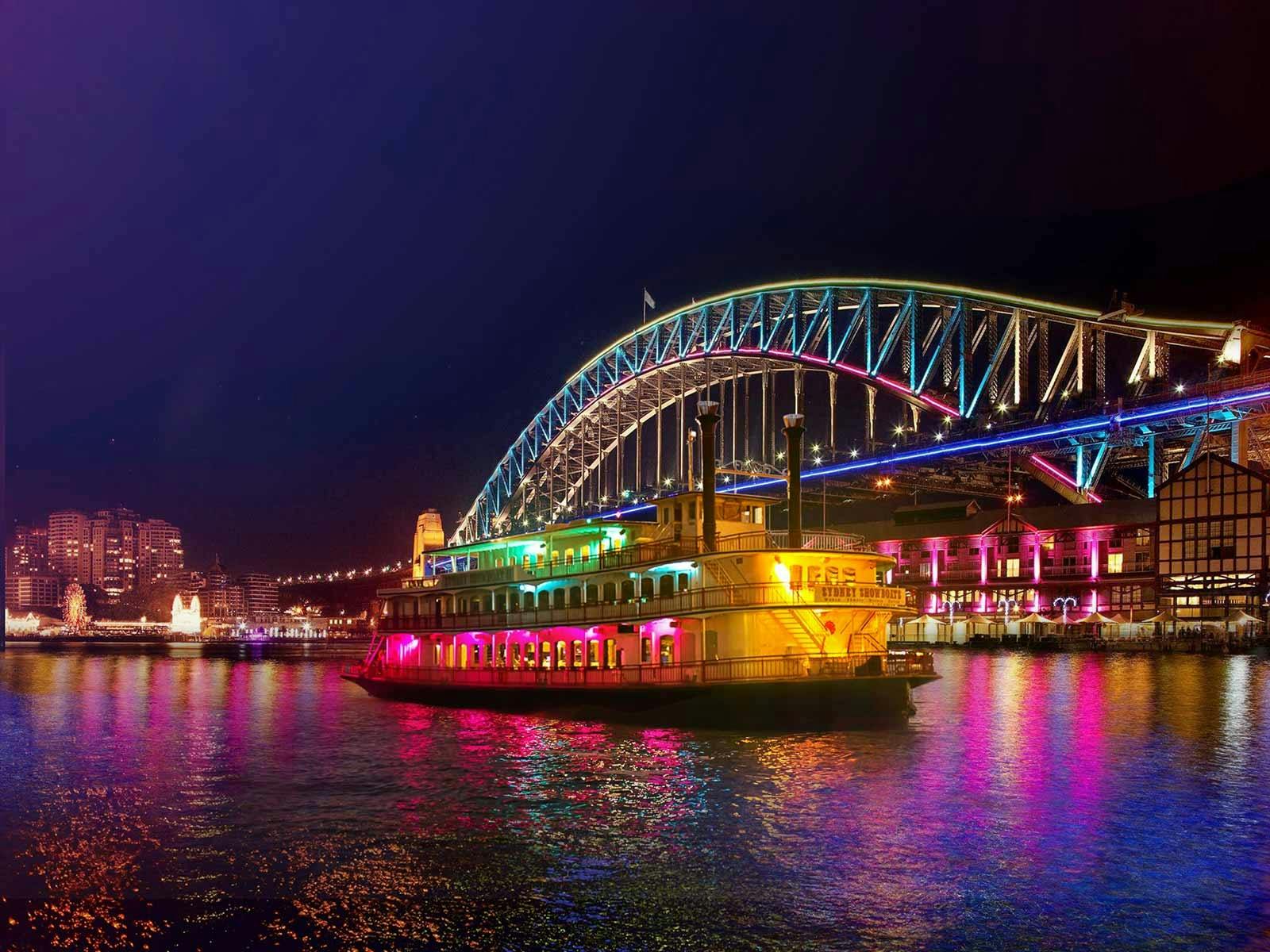 The Showboat Vivid Sydney dinner cruise gliding past the Sydney Harbour Bridge
