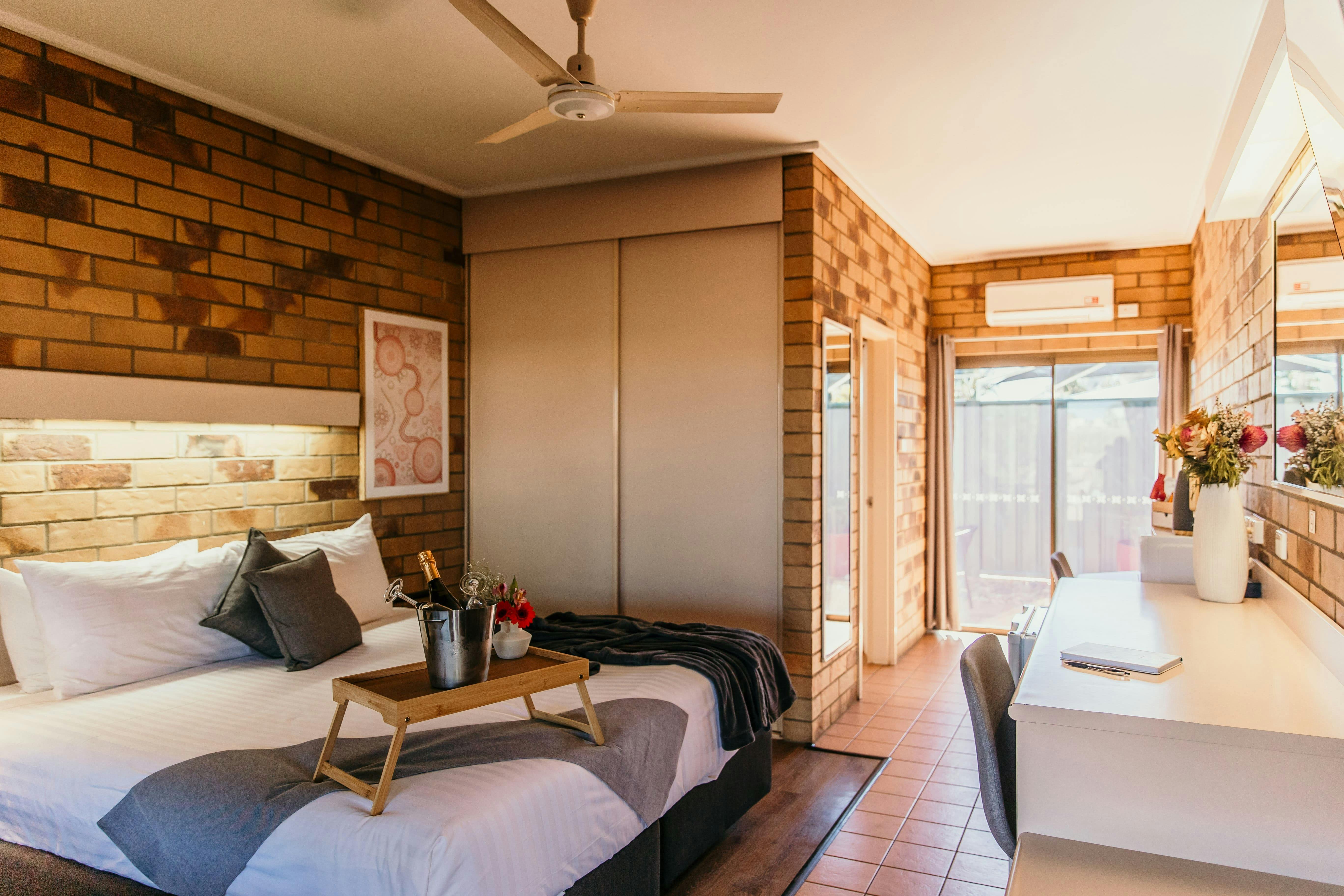 King bed with a robe, cheese platter and champagne ice bucket.
