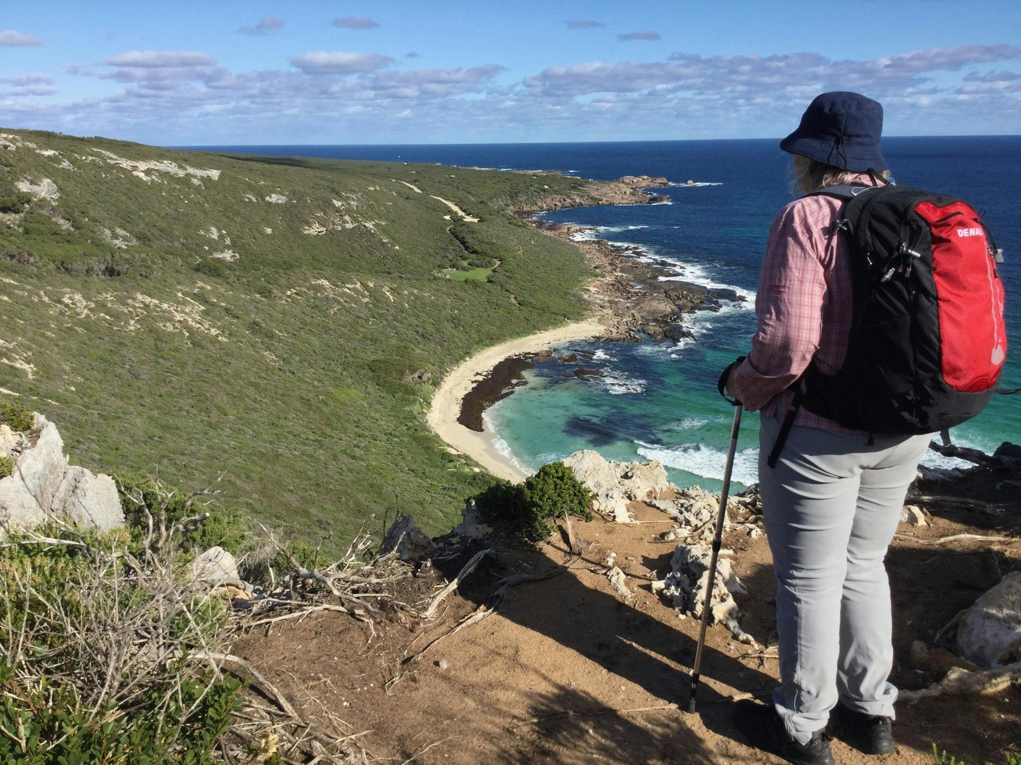 Solo female hiker looks at views of coastline