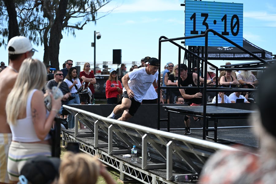 Two athletes chase each other around obstacles