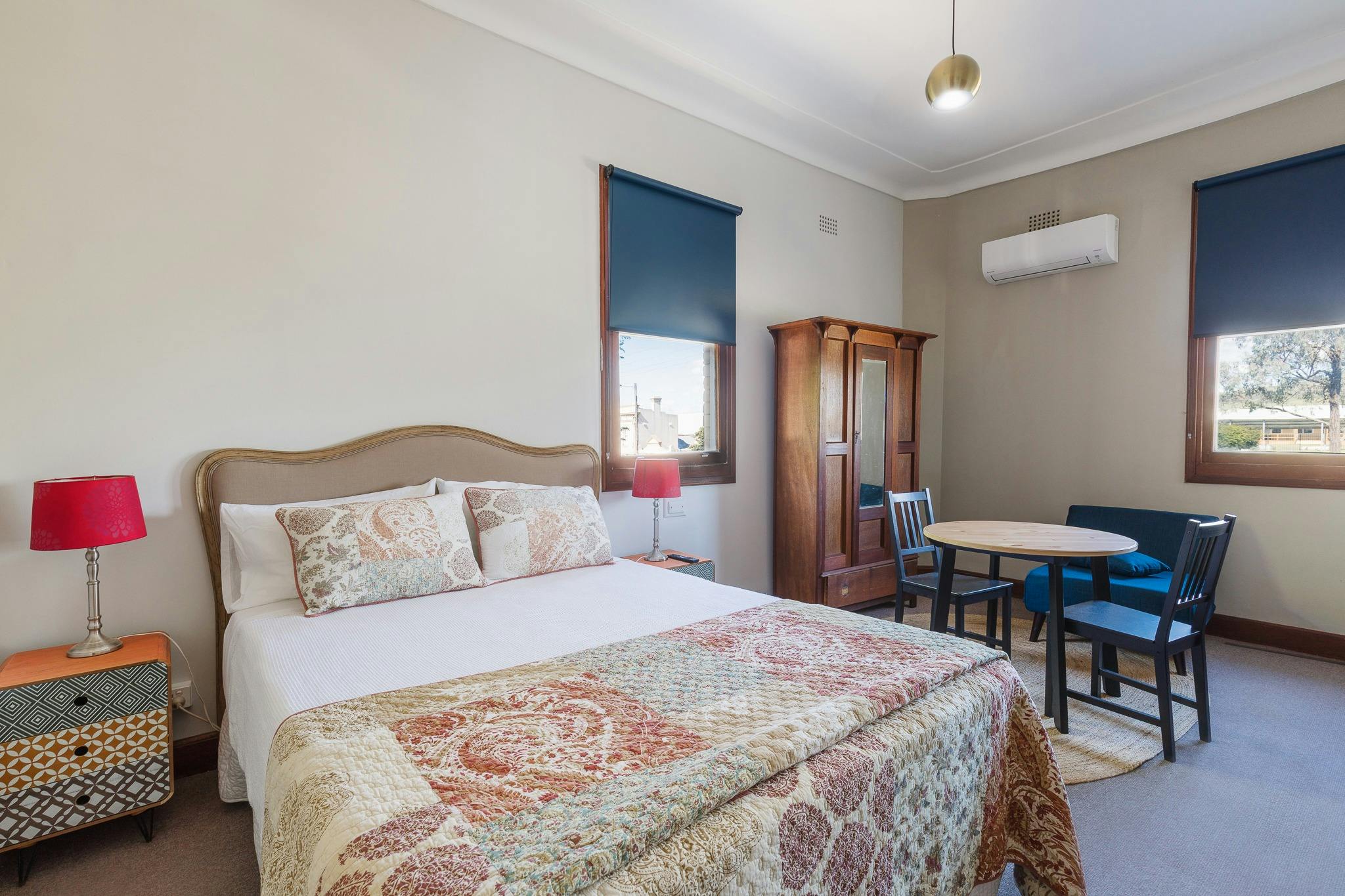 Large room two windows queen bed white linen colorful lamps