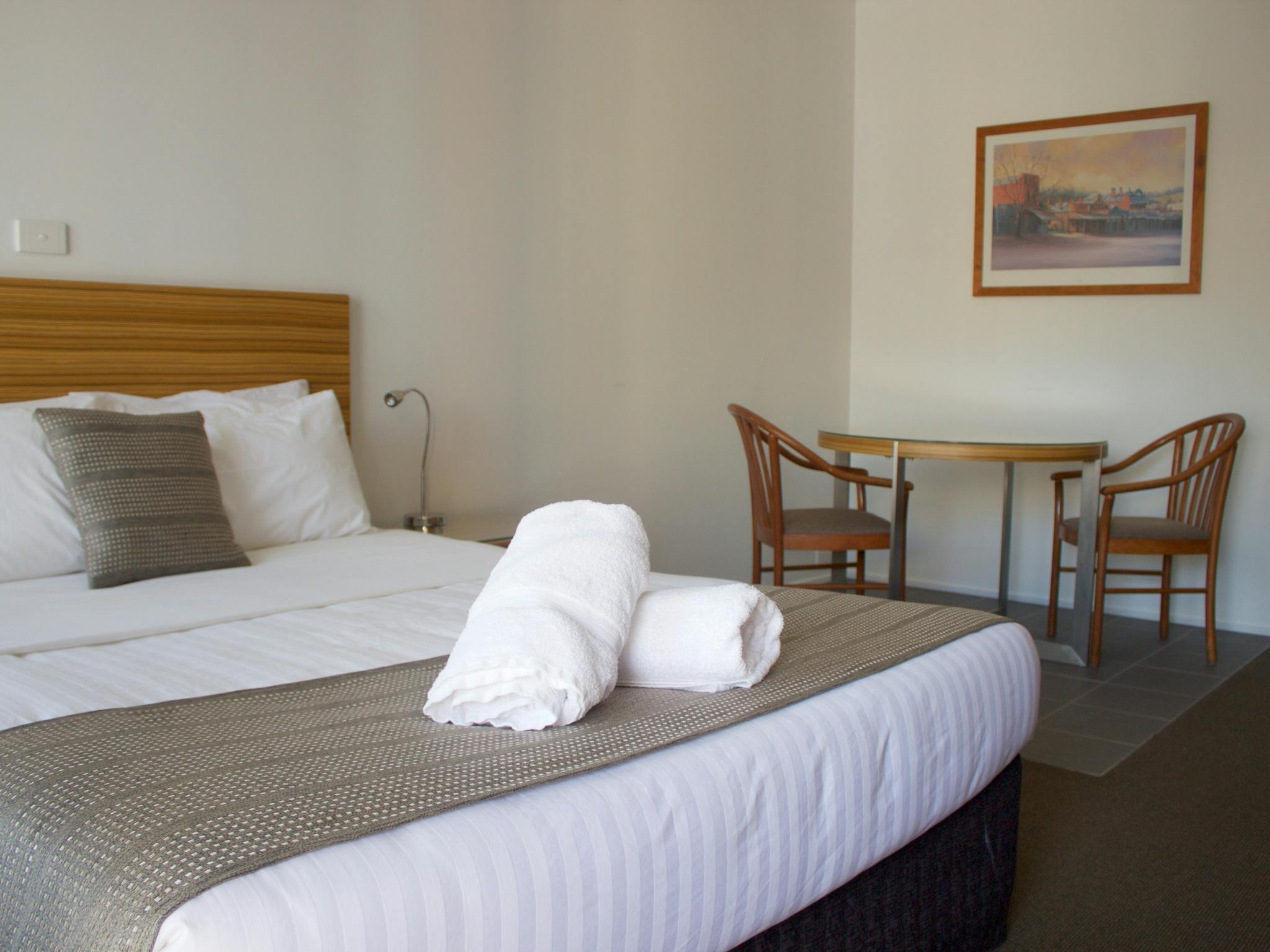 Guest room with queen bed and separate space for dining