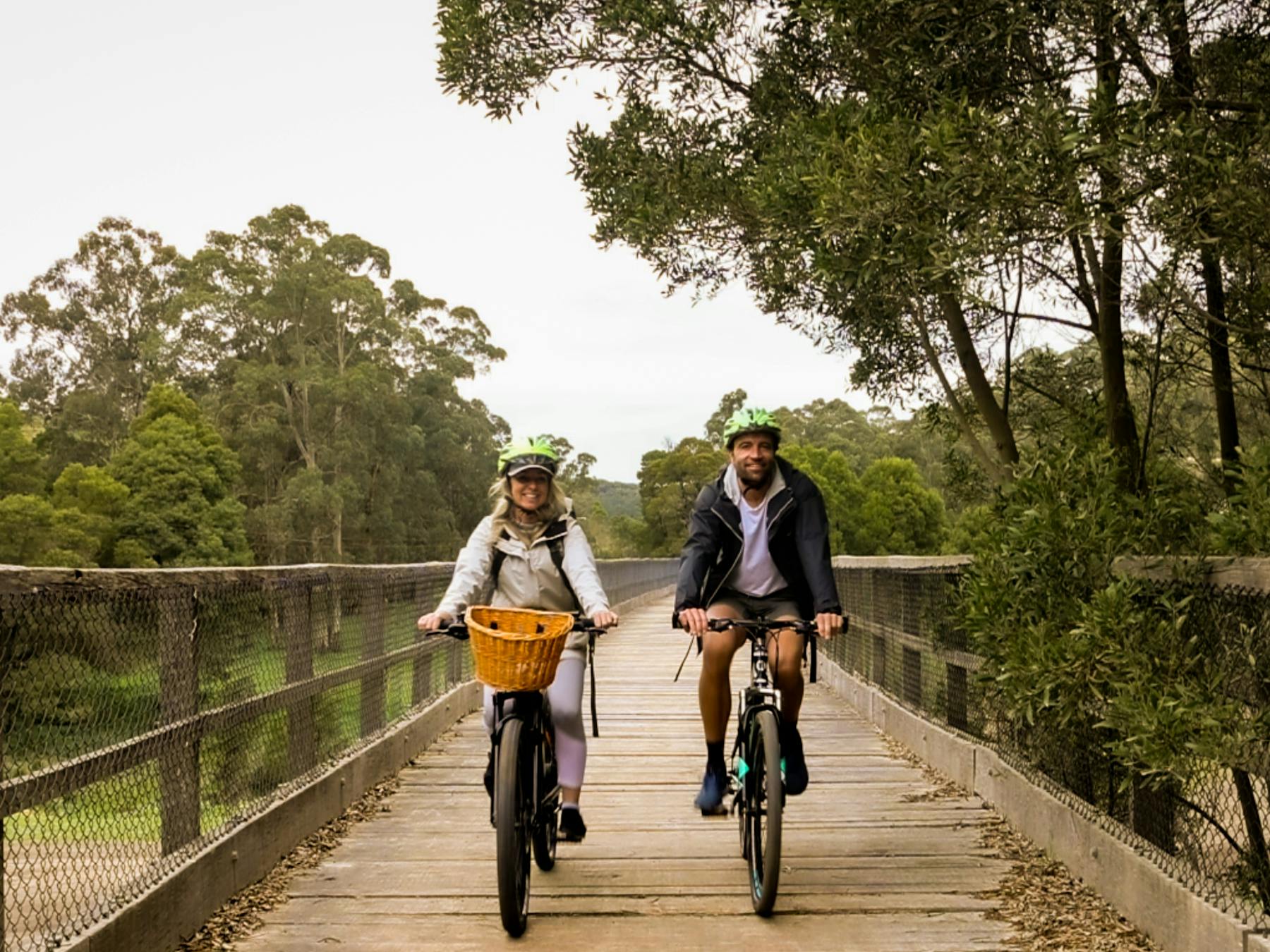Two people riding hire bikes across the Timboon Trestle Bridge on Camperdown to Timboon Rail Trail