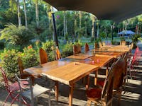 Timber long table in sunlight surrounded by trees