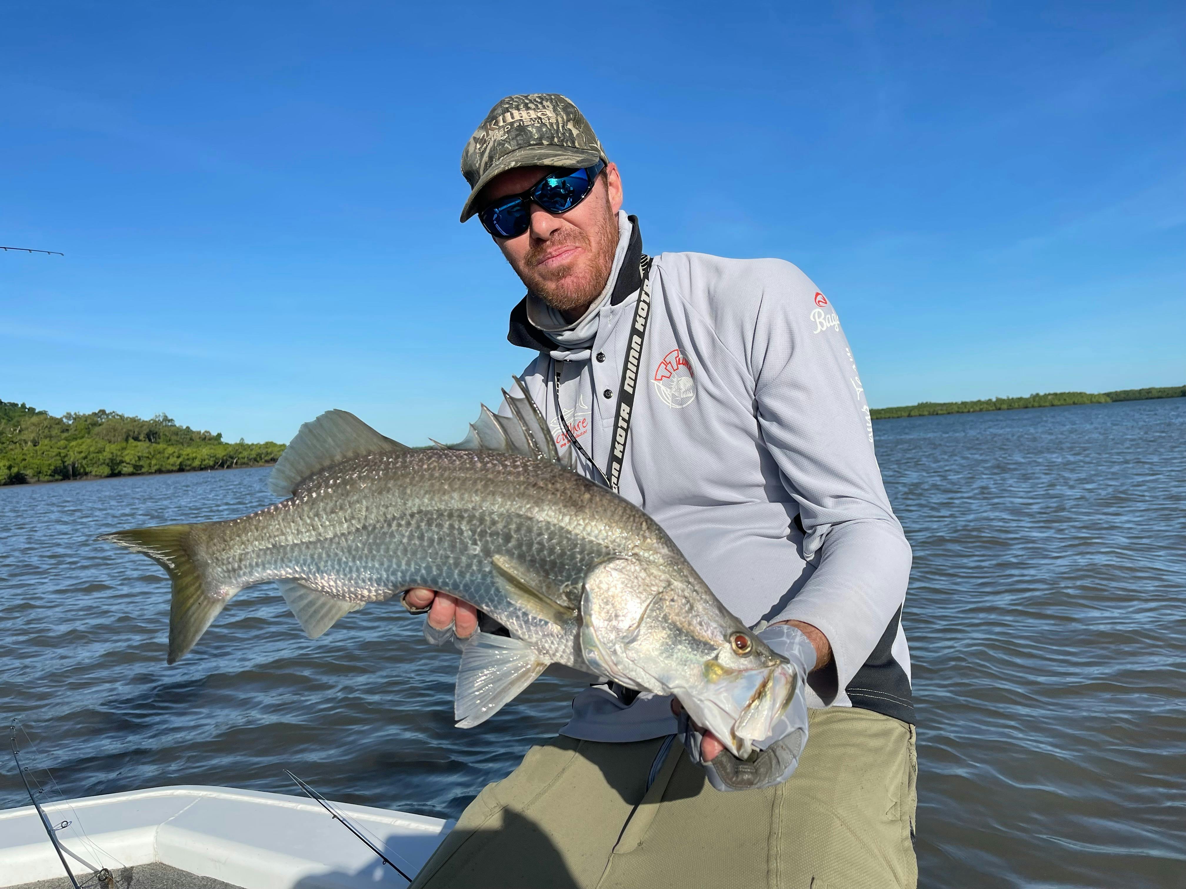 Jeff holding a chrome colored Barramundi caught in the Hinchinbrook channel