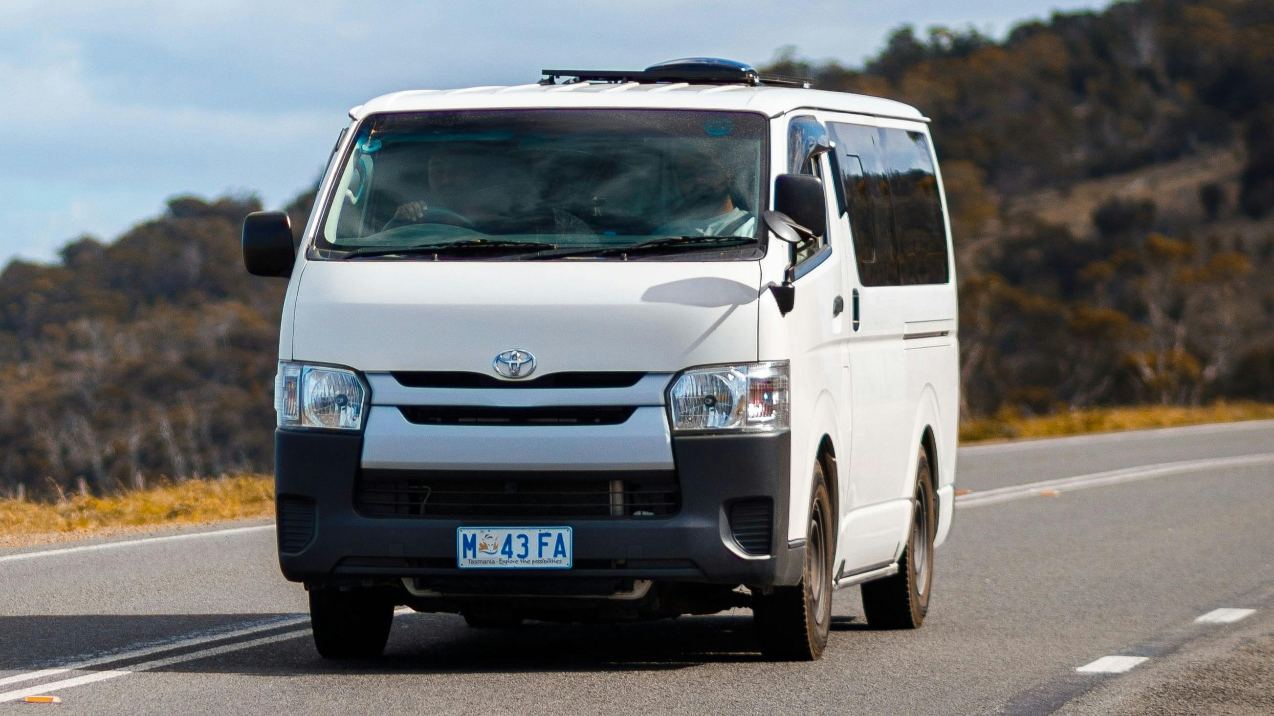 Yana 4WD van navigating scenic off-grid roads surrounded by Tasmanian wilderness.