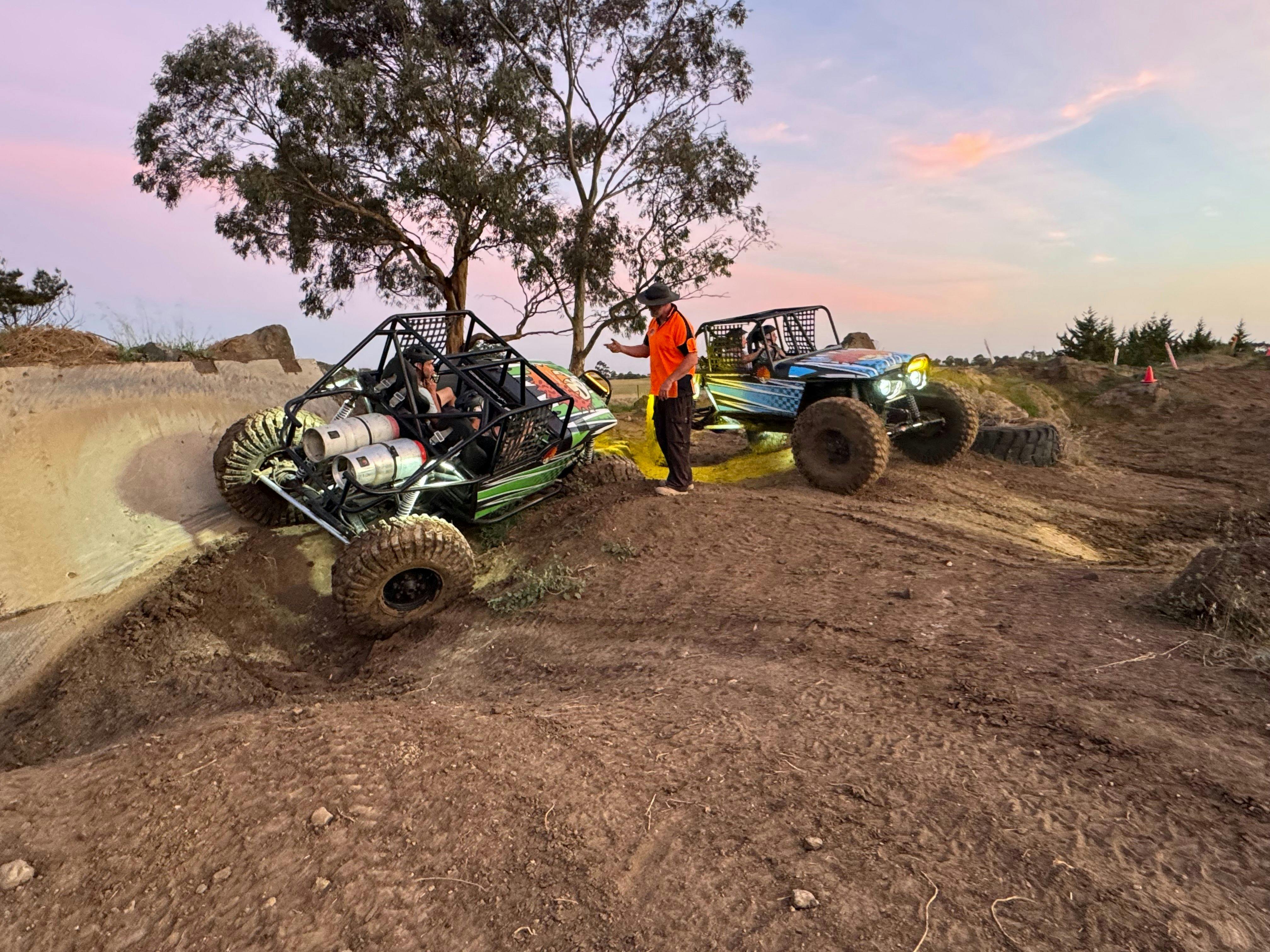 Two 4x4 vehicles and an instructor in the middle
