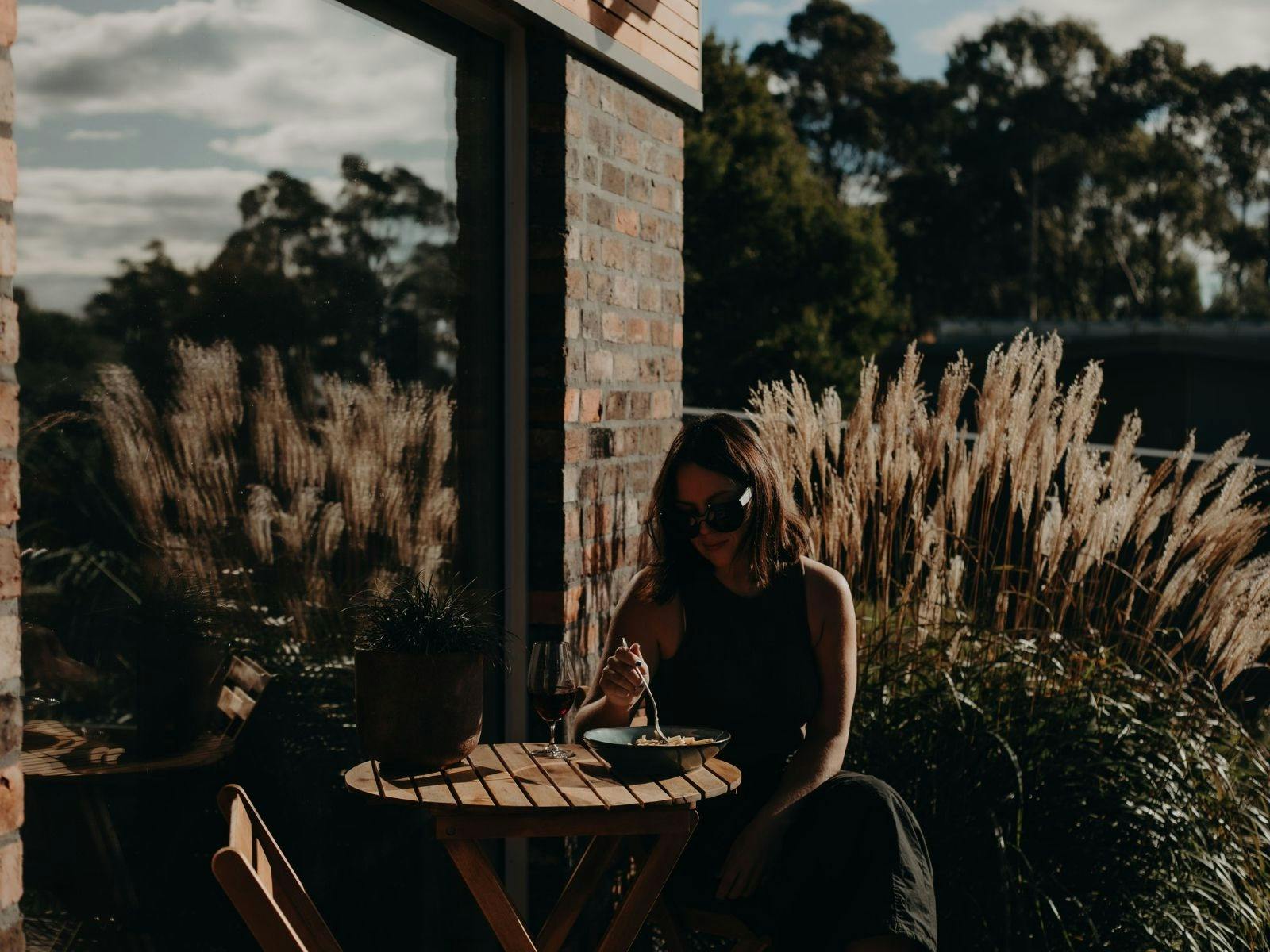 woman sitting on a deck eating