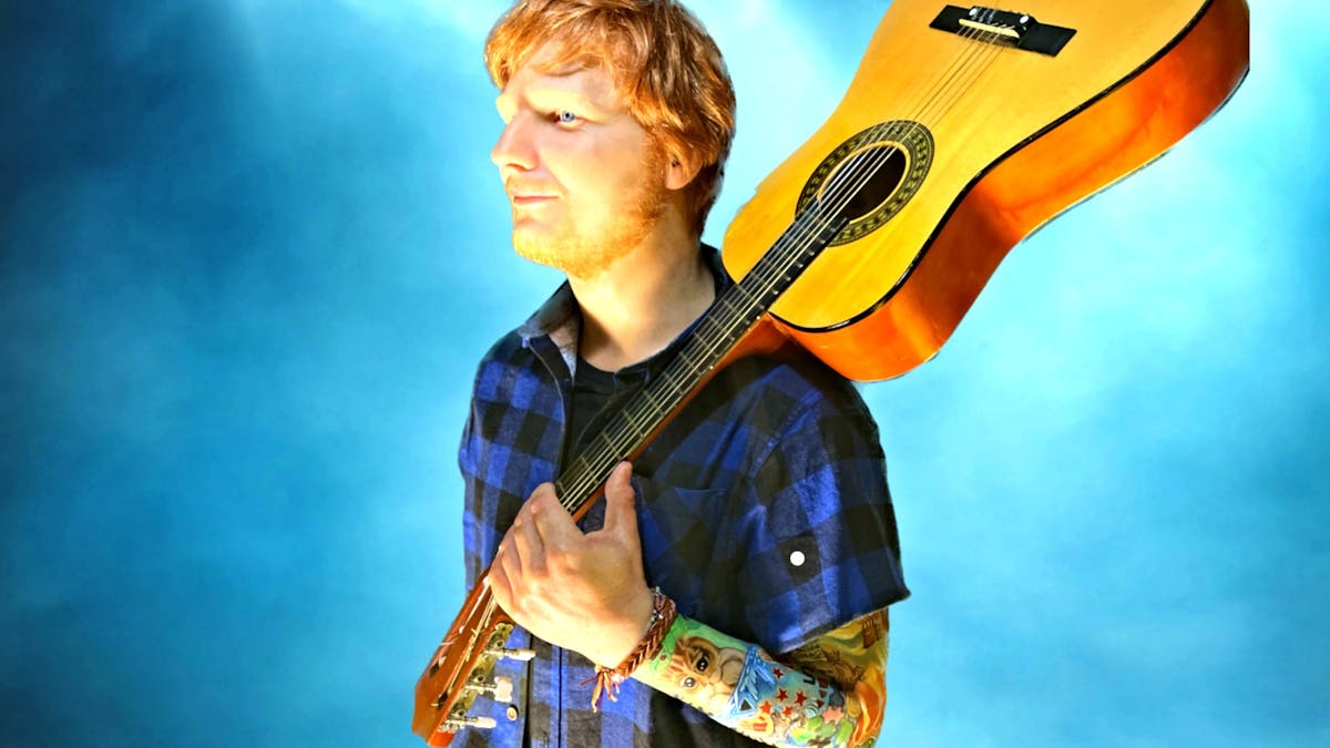 Ed Sheeran blue background  with a guitar on shoulder