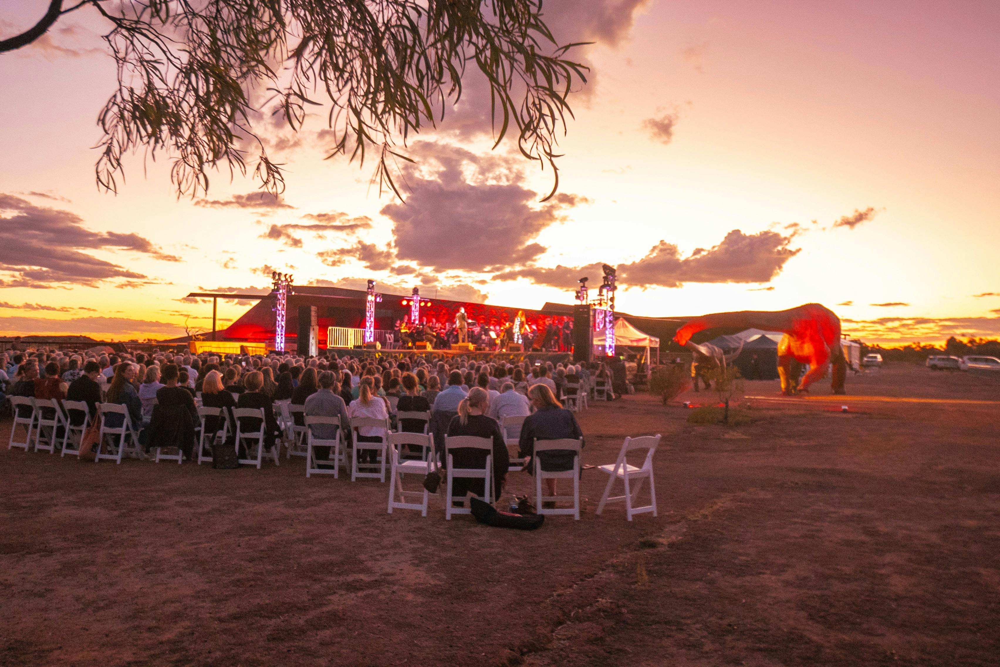 Group of people listening to opera during sunset at the Australian Age of Dinosaurs