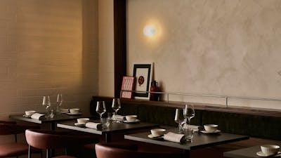 Three tables set with cutlery and glassware, comfortable chairs, and a dining room that feels homely