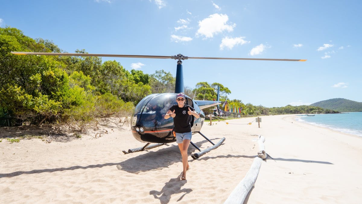 Helicopter running on a beach with a staff member excitedly with thumbs up exiting the helicopter Helicopter running on a beach with a staff member excitedly with thumbs up exiting the helicopter