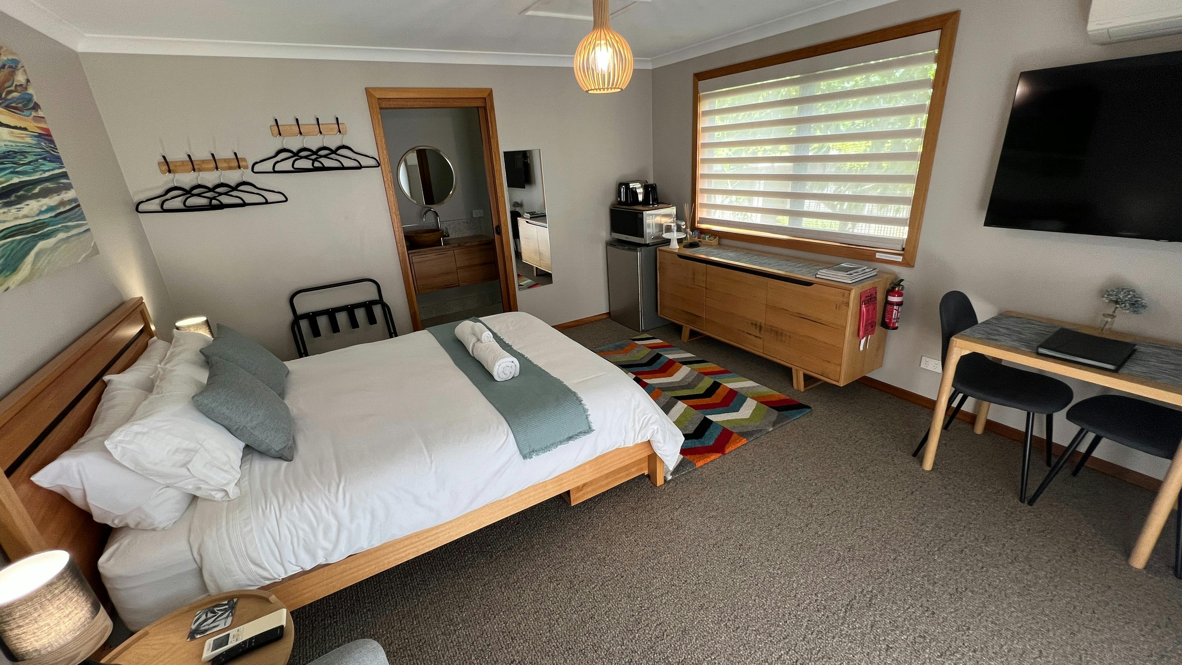 Queen bed, fridge, microwave, kettle, toaster, dining table and chairs, TV