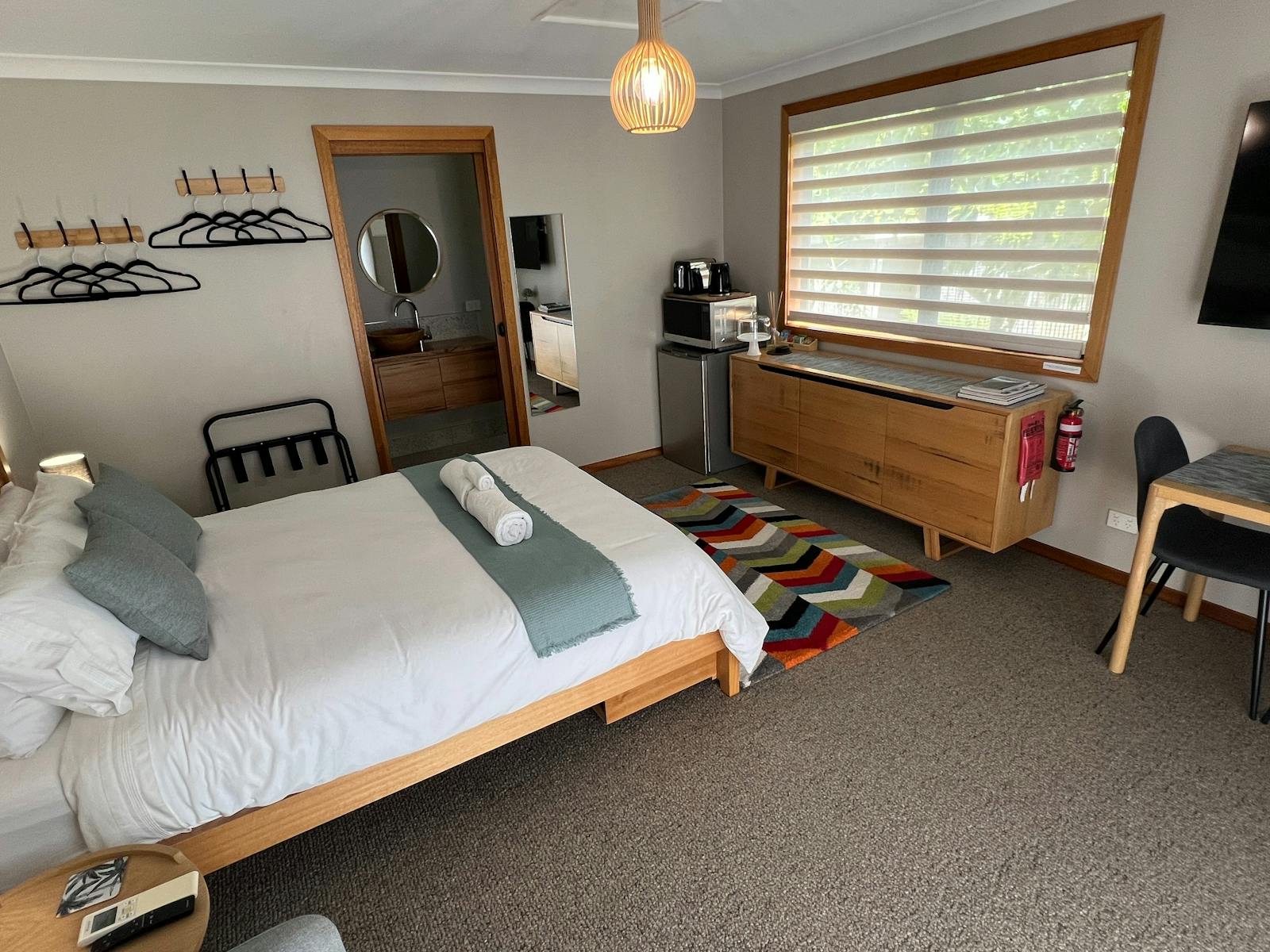 Queen bed, fridge, microwave, kettle, toaster, dining table and chairs, TV