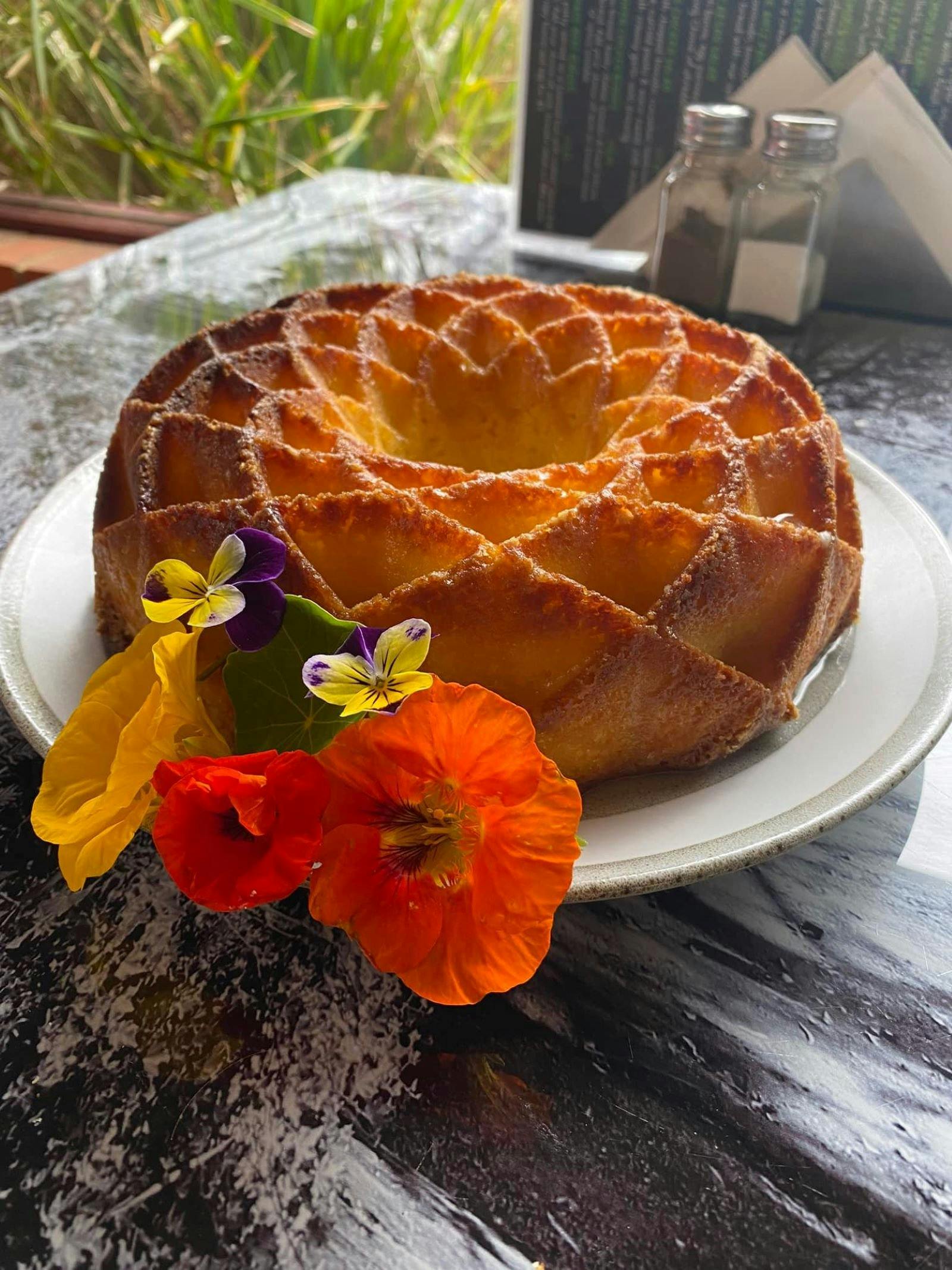 Carrot cake with decorated flowers on the side.