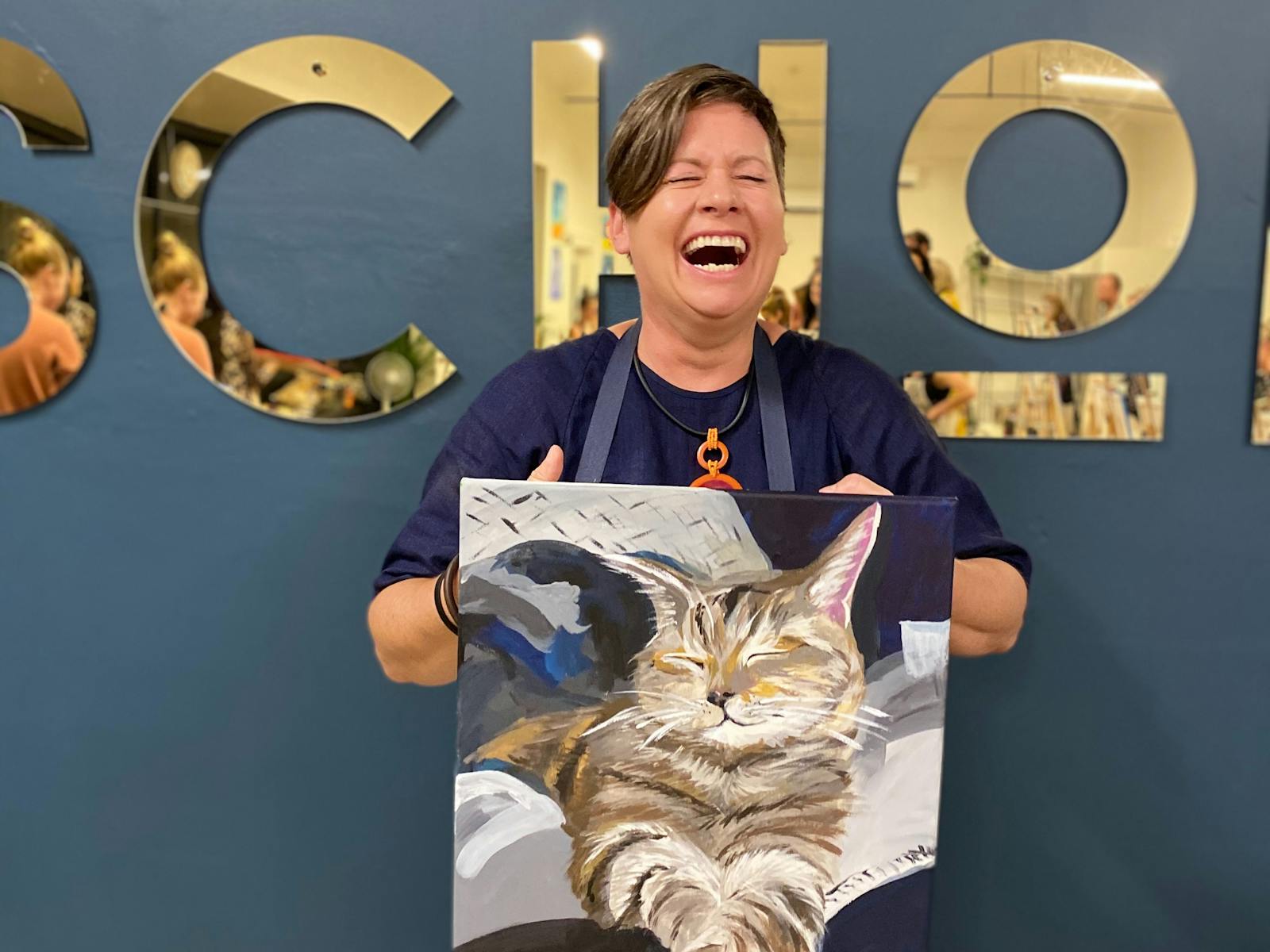 A laughing lady with her masterpiece paint your pet