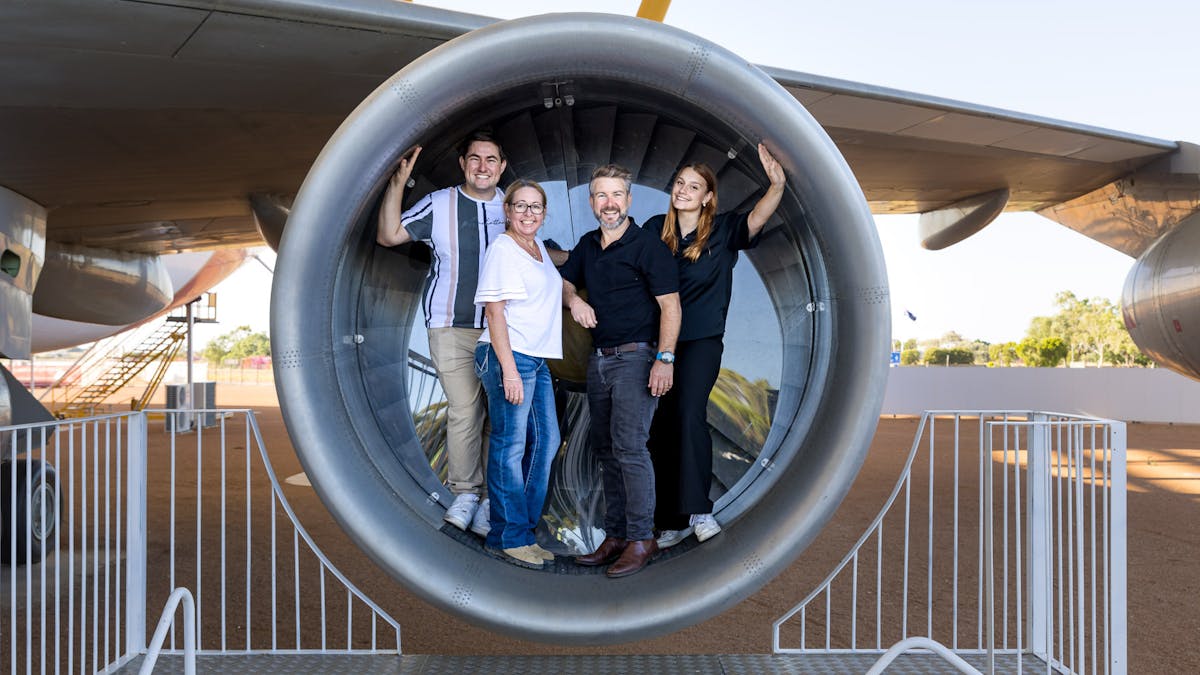 four guests standing in the 747 engine intake for a photo opportunity on tour