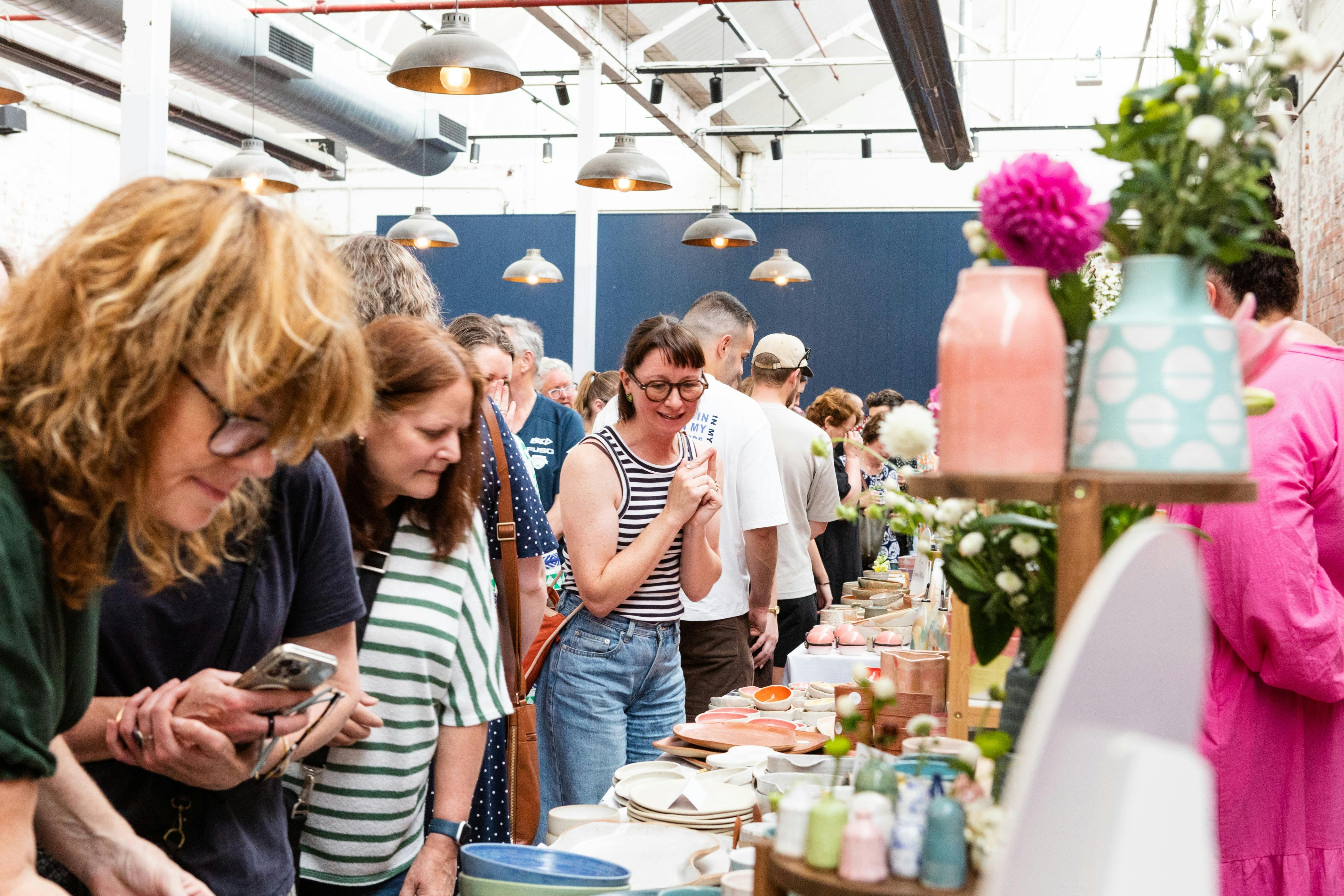 Crowds browsing handmade ceramics at the Geelong Ceramics Market inside Furphy Hall