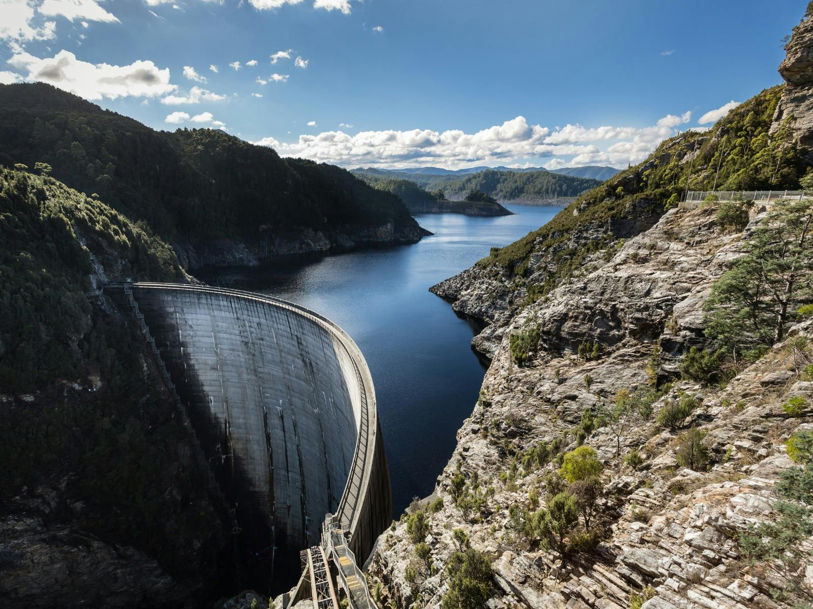 Sunny skies overlooking the Gordon Dam with reflections in the water
