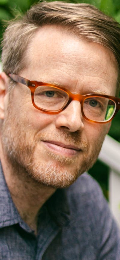 A man wearing glasses and a dark grey shirt