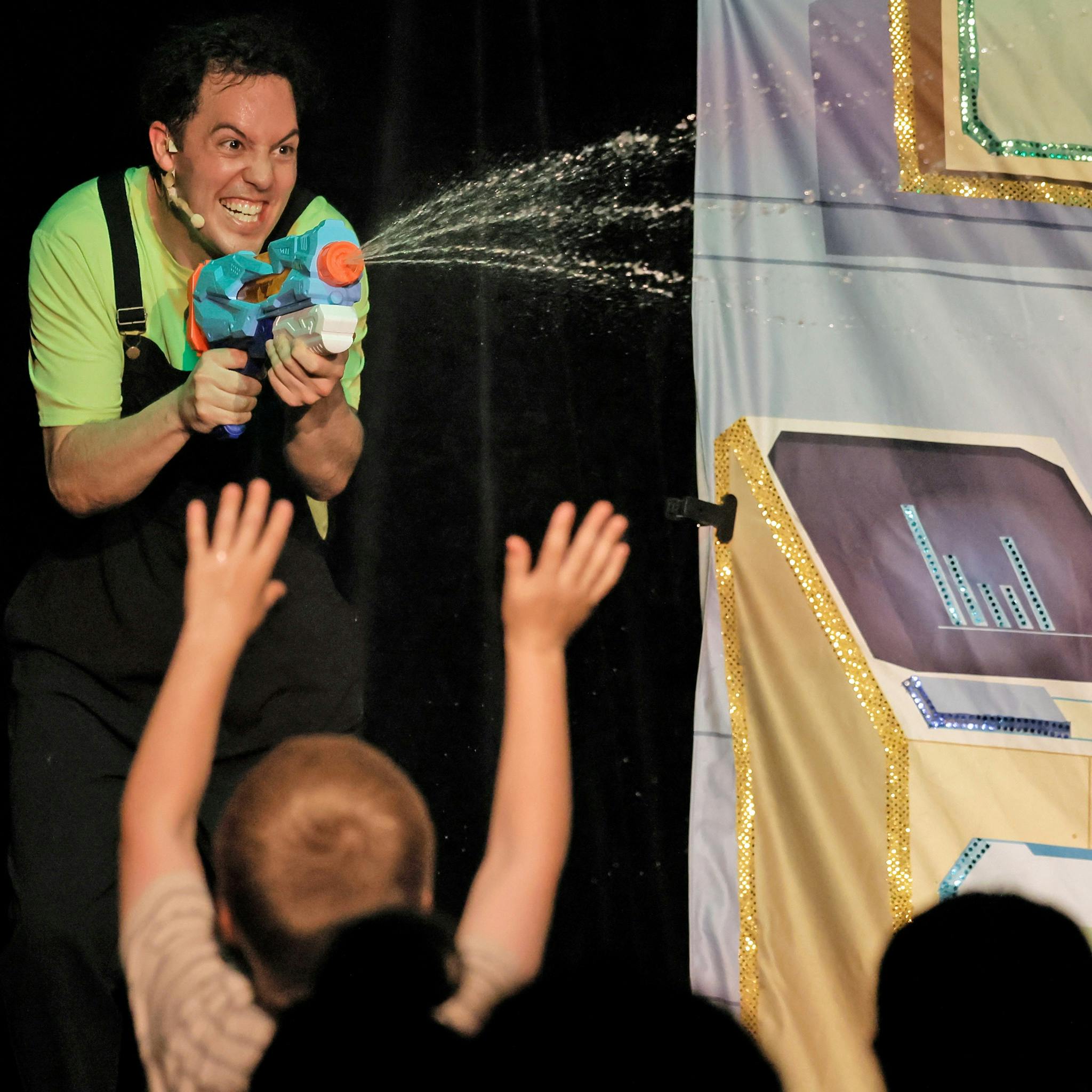 Cheeky looking man squirting a water pistol into a crowd