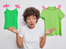 Young woman trying to decide between 2 shades of green