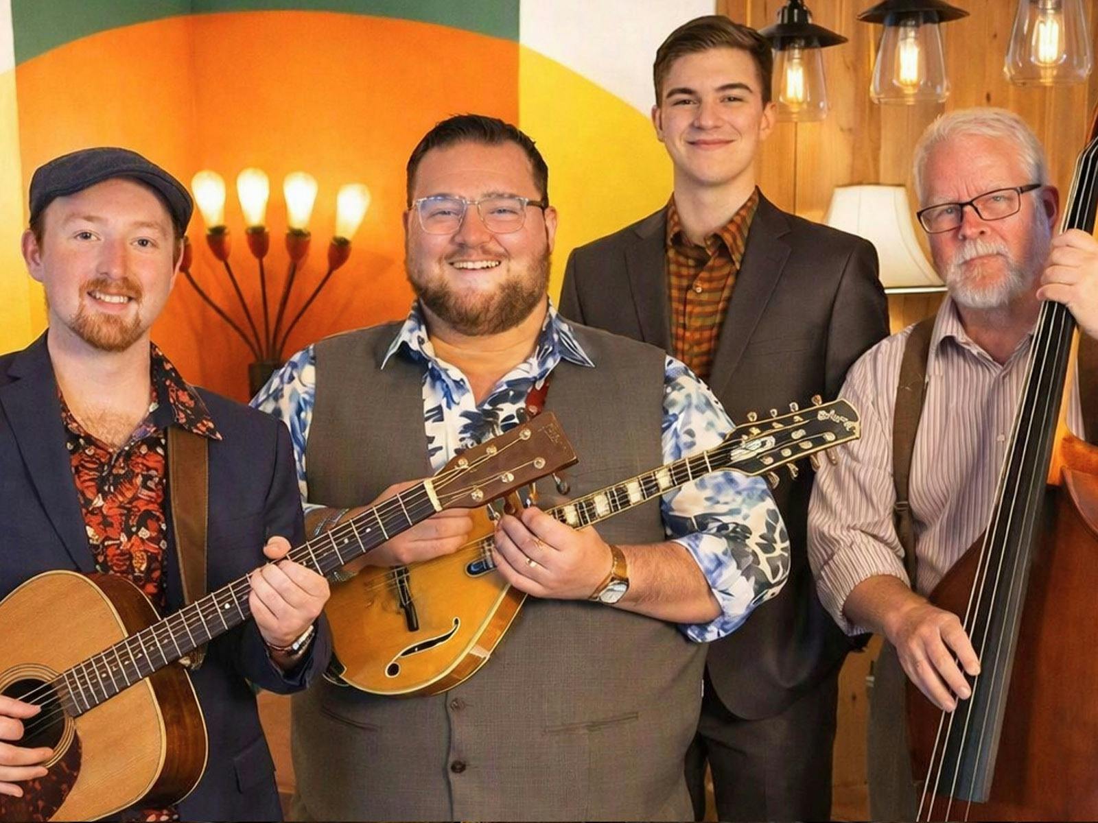 A group of bluegrass musicians holding their instruments including guitar, banjo and double bass
