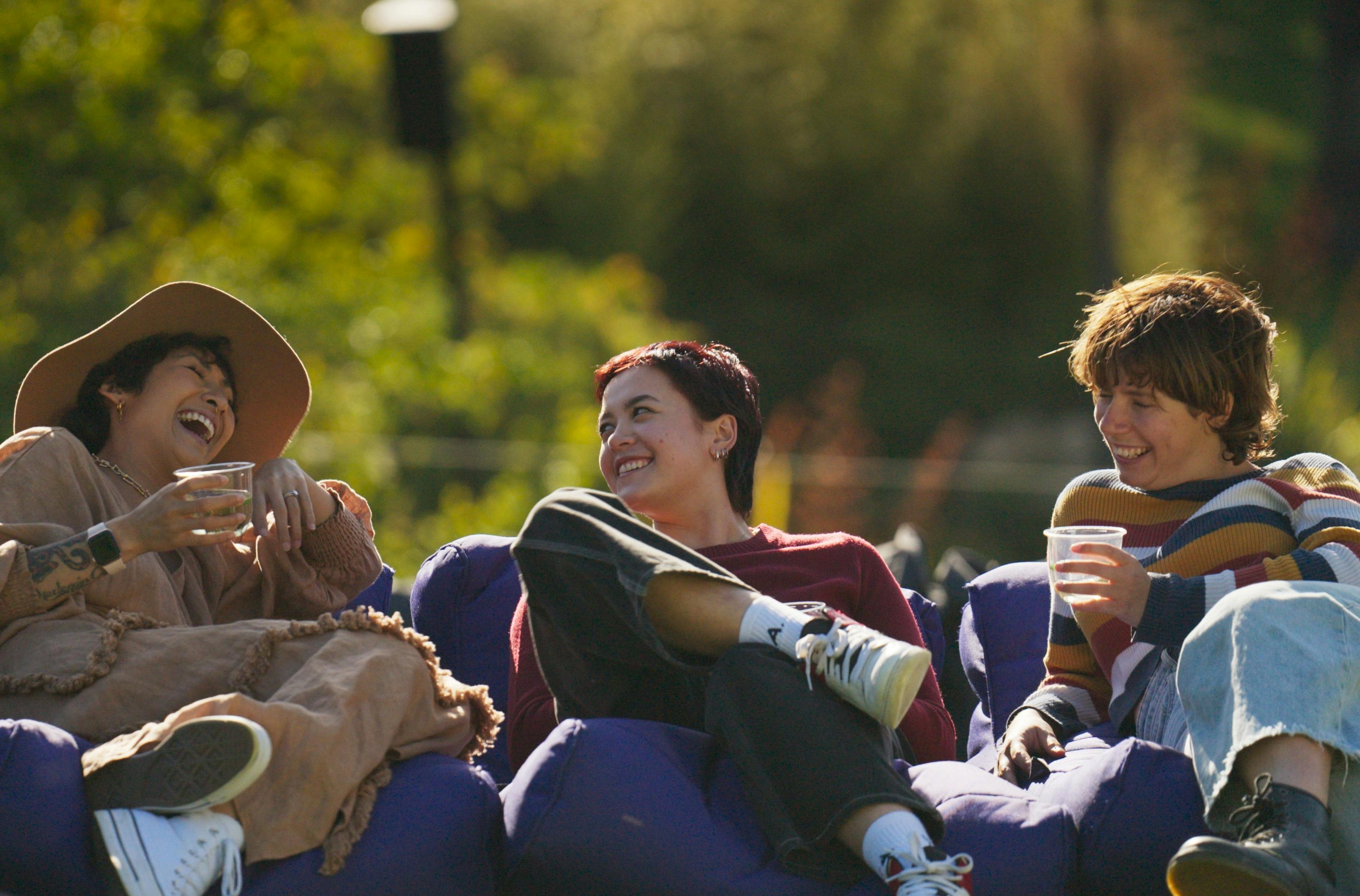 Eine Gruppe von Menschen hält Getränke in der Hand und lacht.
